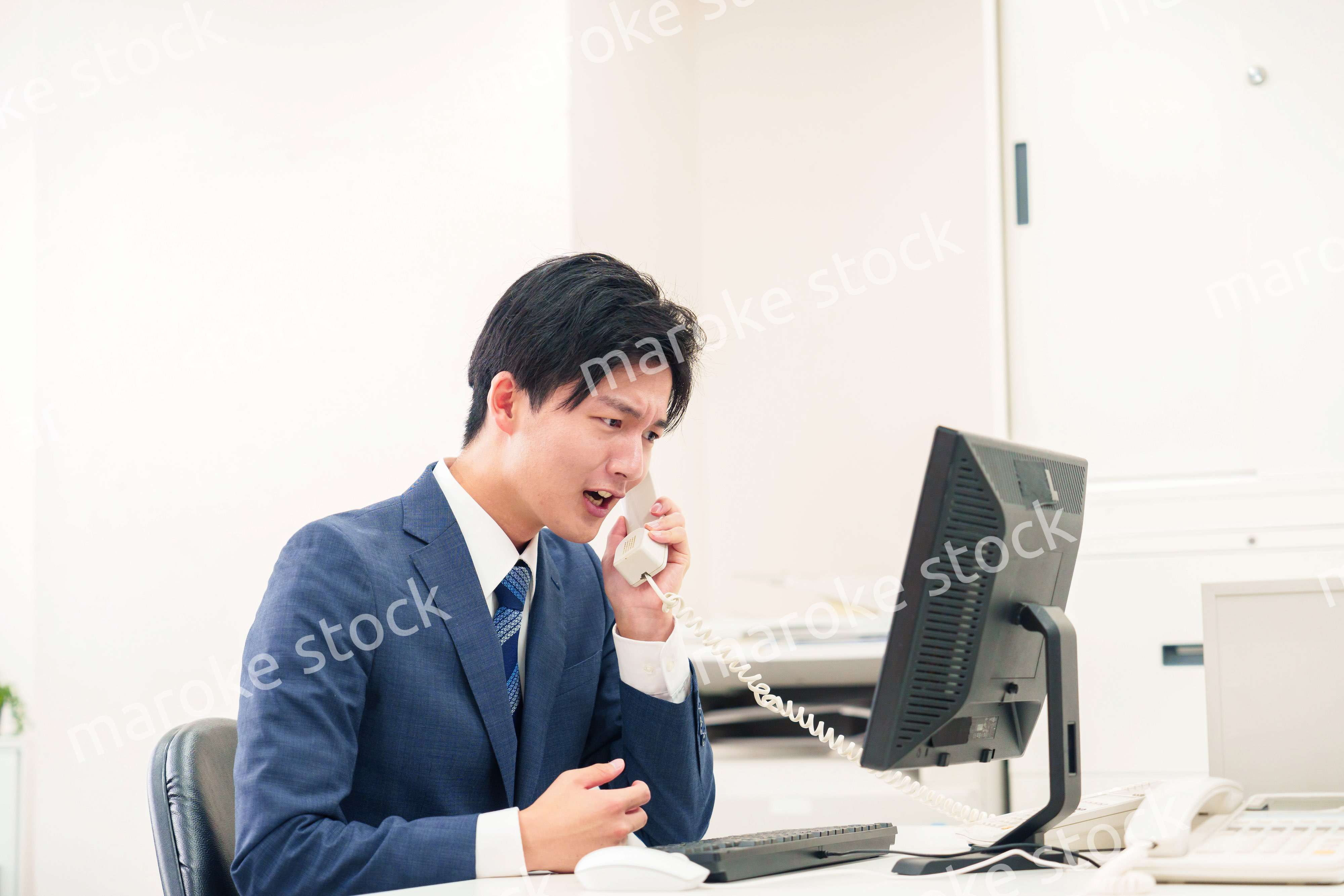 電話で怒鳴るビジネスマンの男性