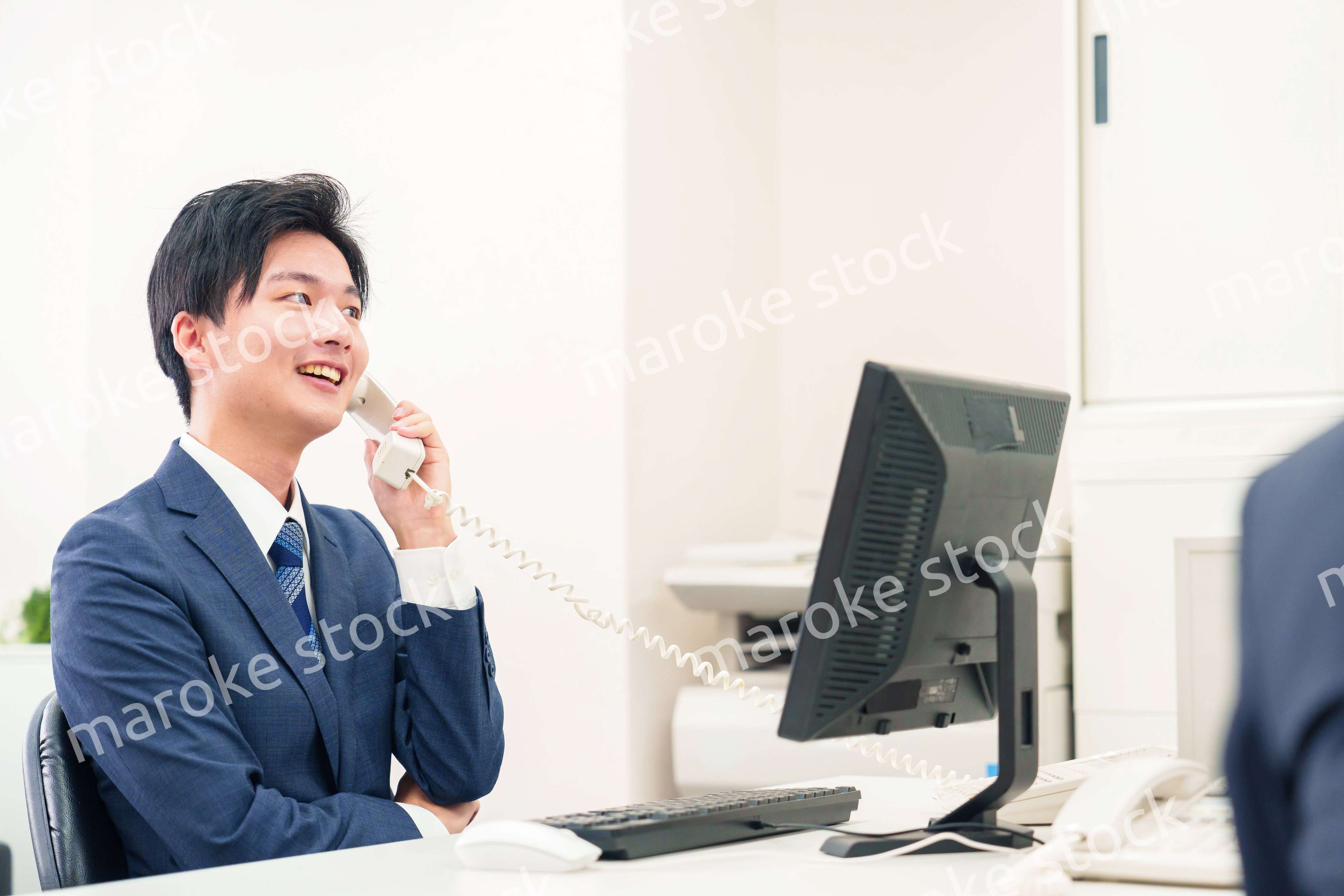 オフィスの電話で話すビジネスマン