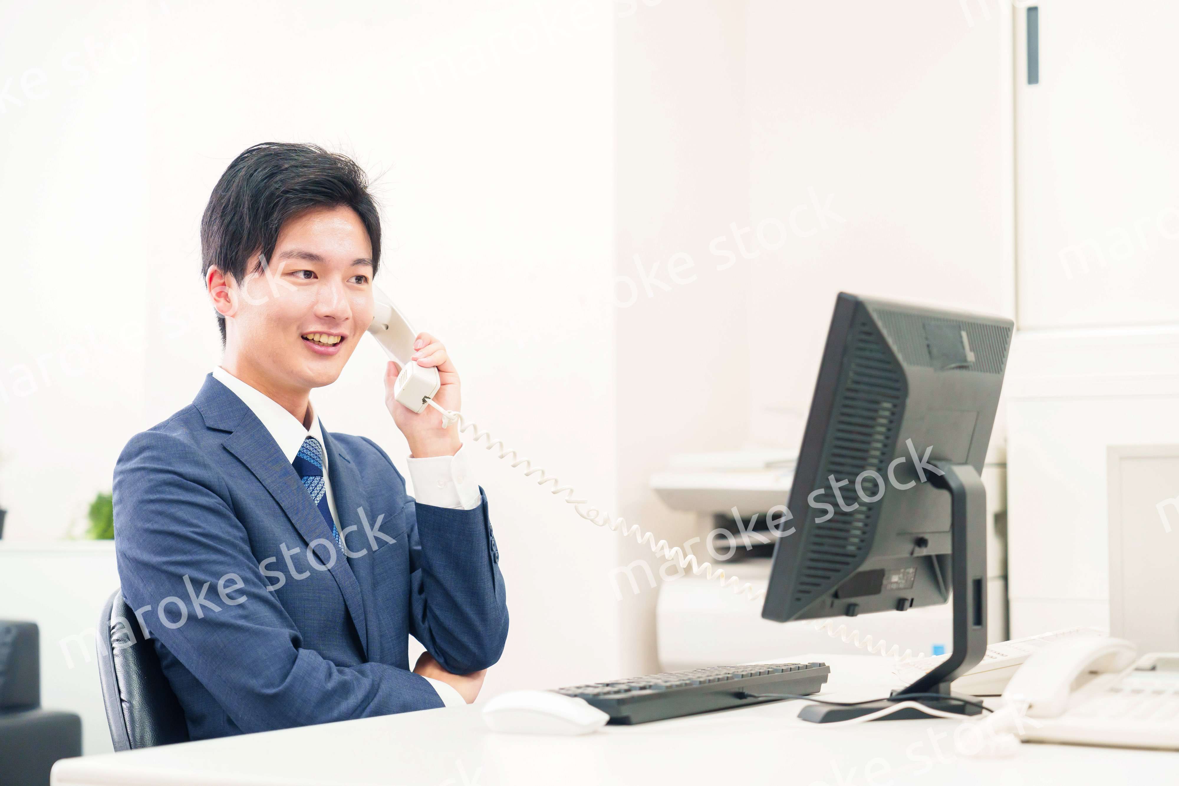 オフィスの電話で話すビジネスマン