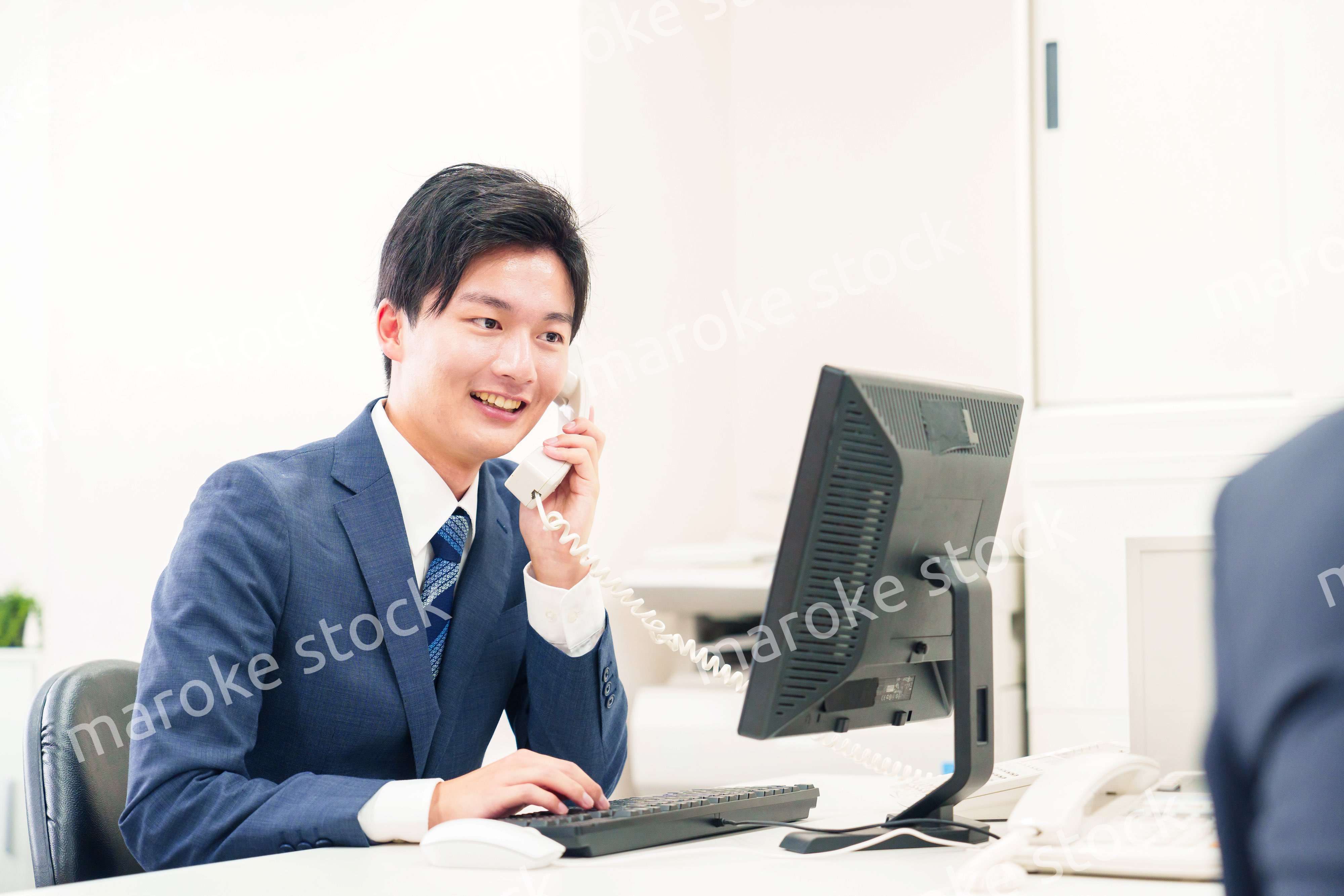 オフィスの電話で話すビジネスマン