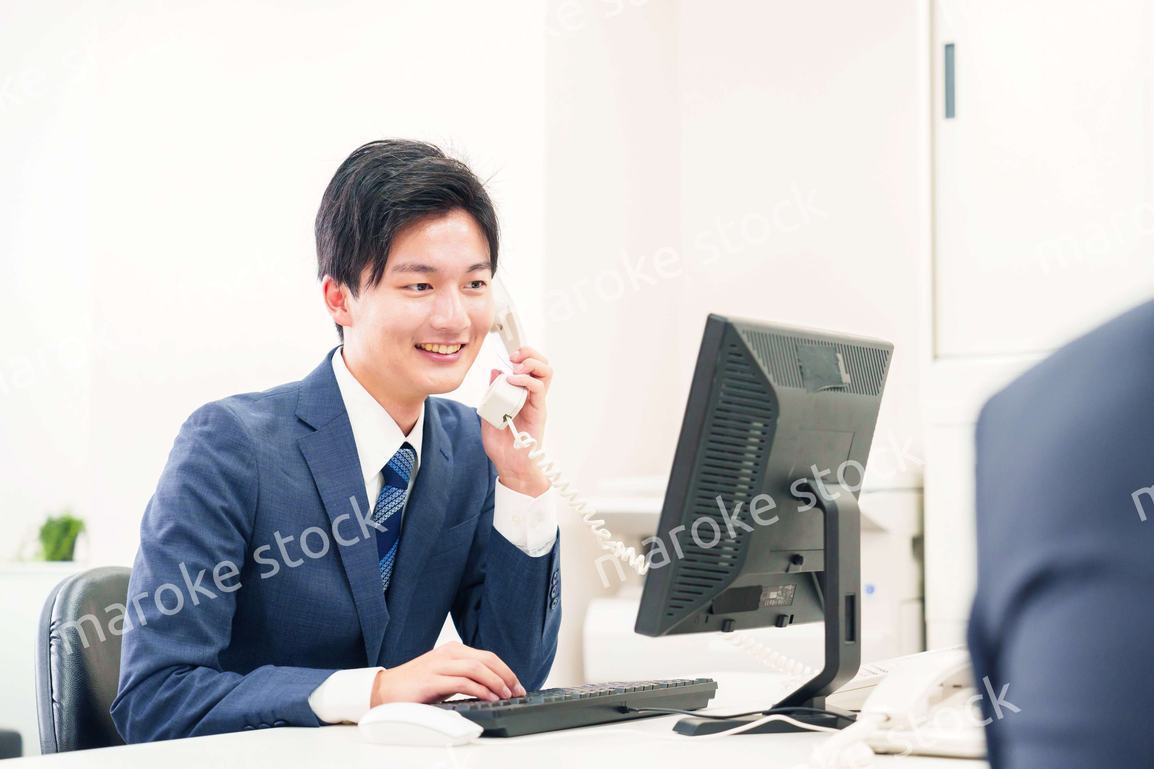 オフィスの電話で話すビジネスマン