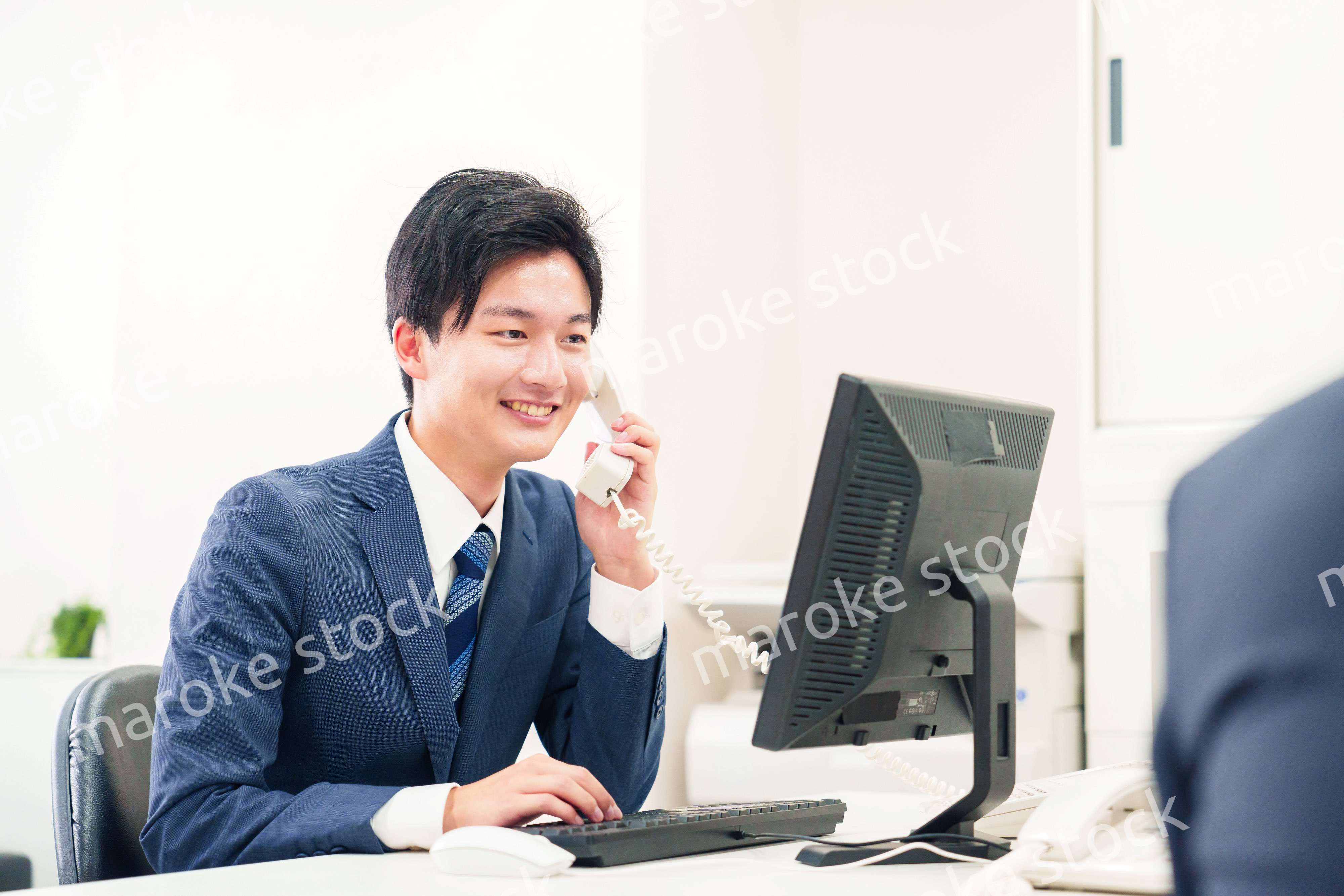 オフィスの電話で話すビジネスマン