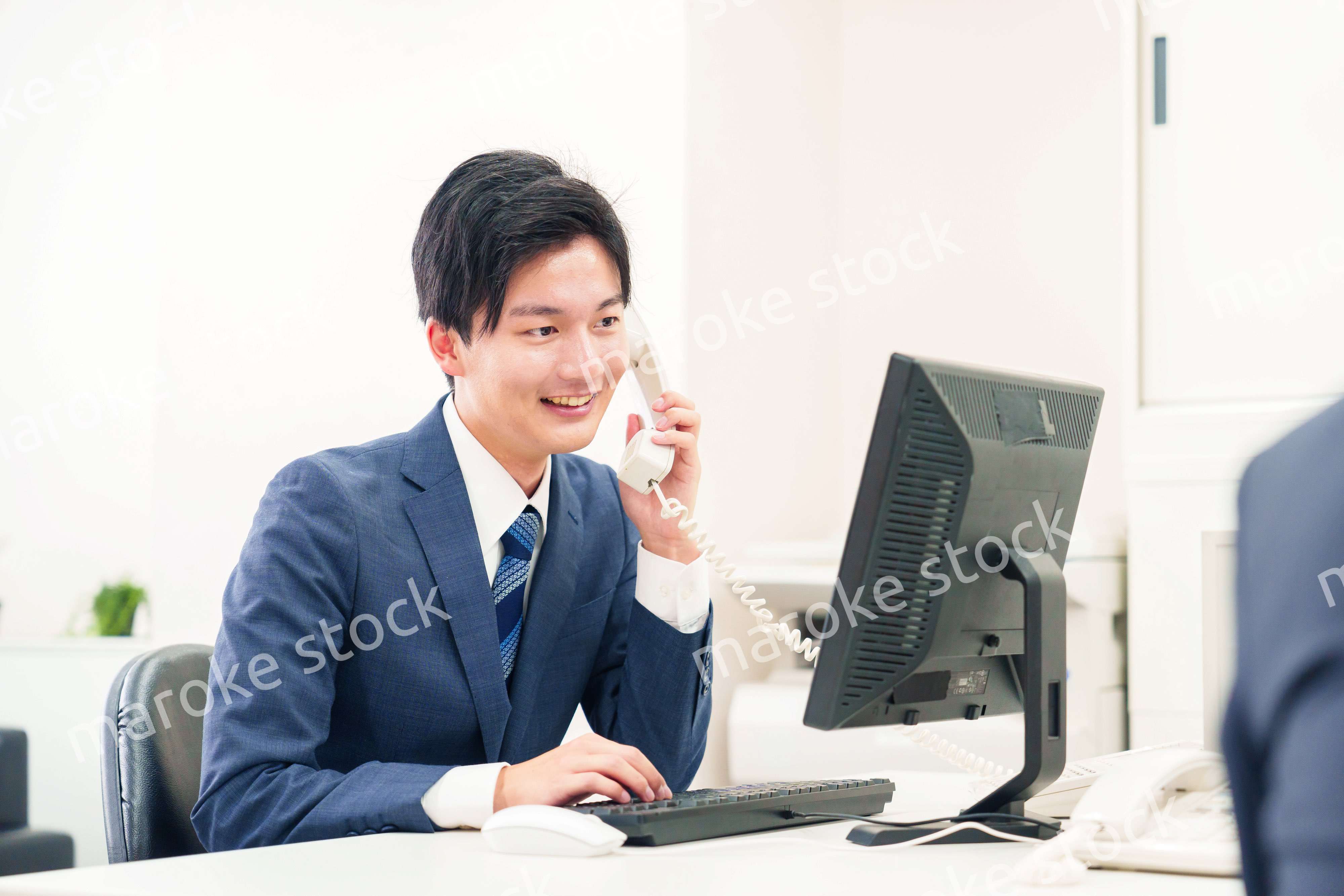 オフィスの電話で話すビジネスマン