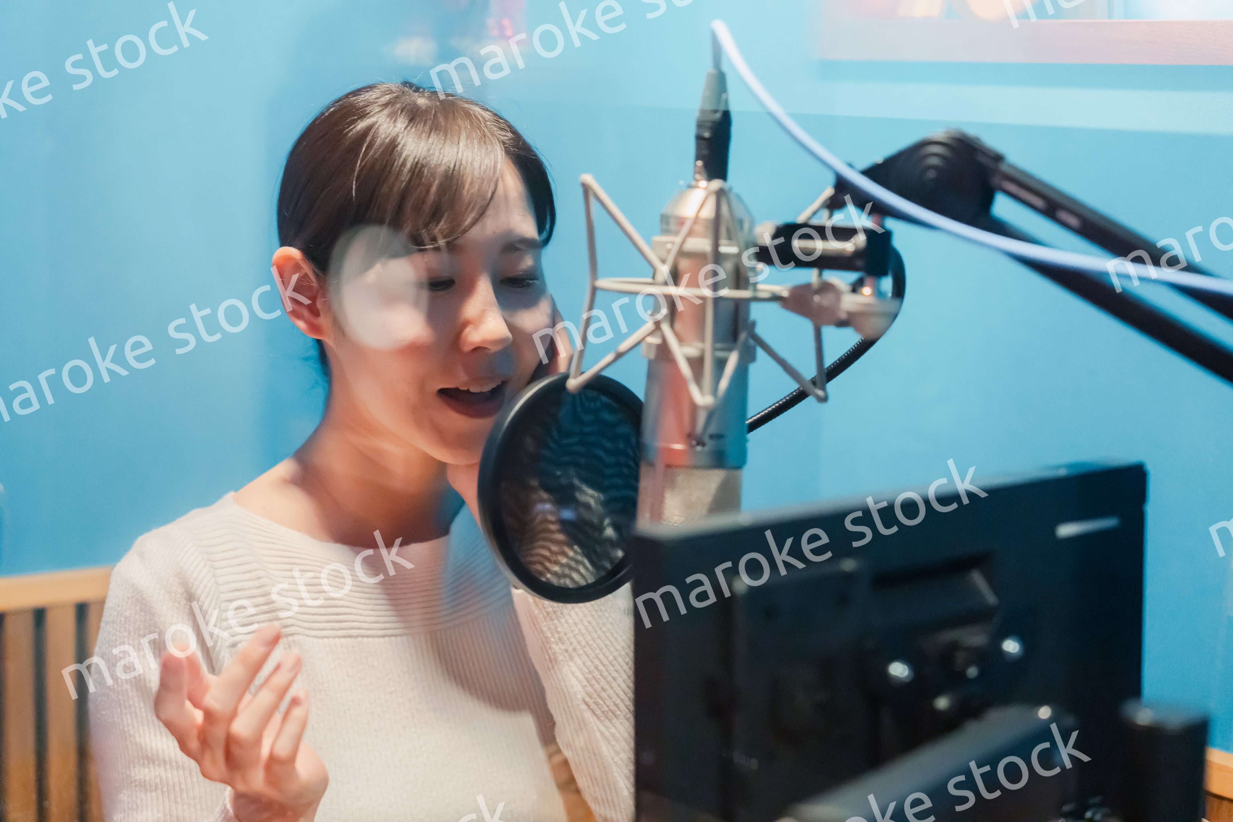 歌の収録をする若い女性