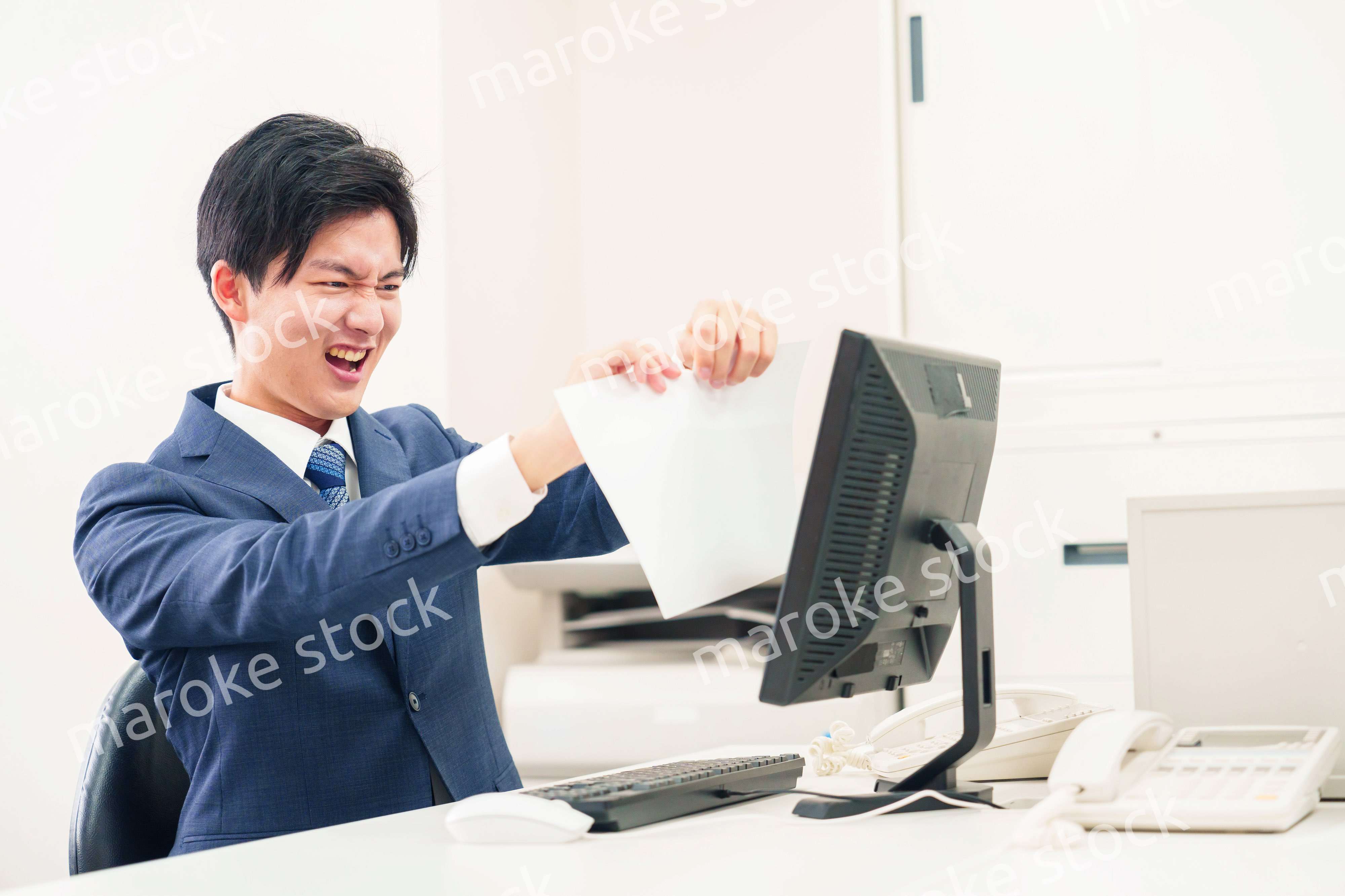 オフィスで書類を破り捨てるビジネスマン