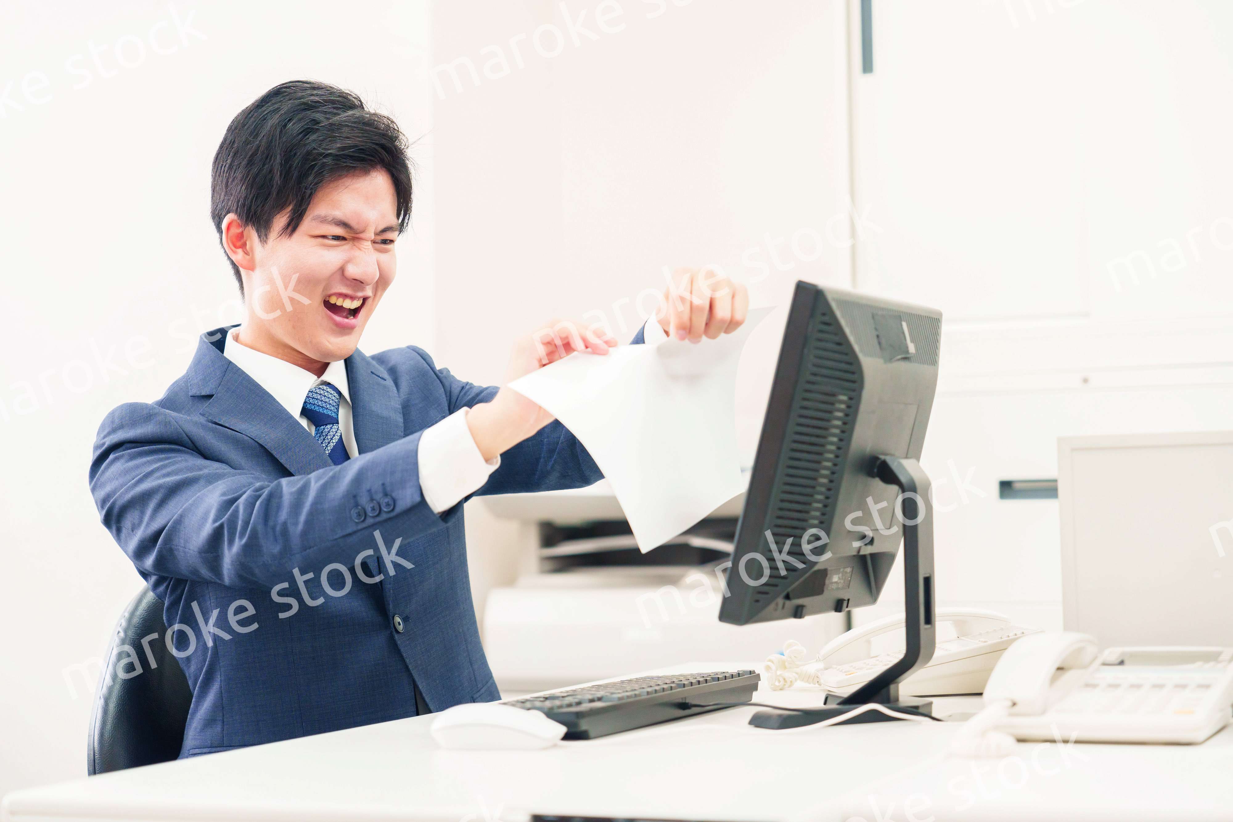 オフィスで書類を破り捨てるビジネスマン