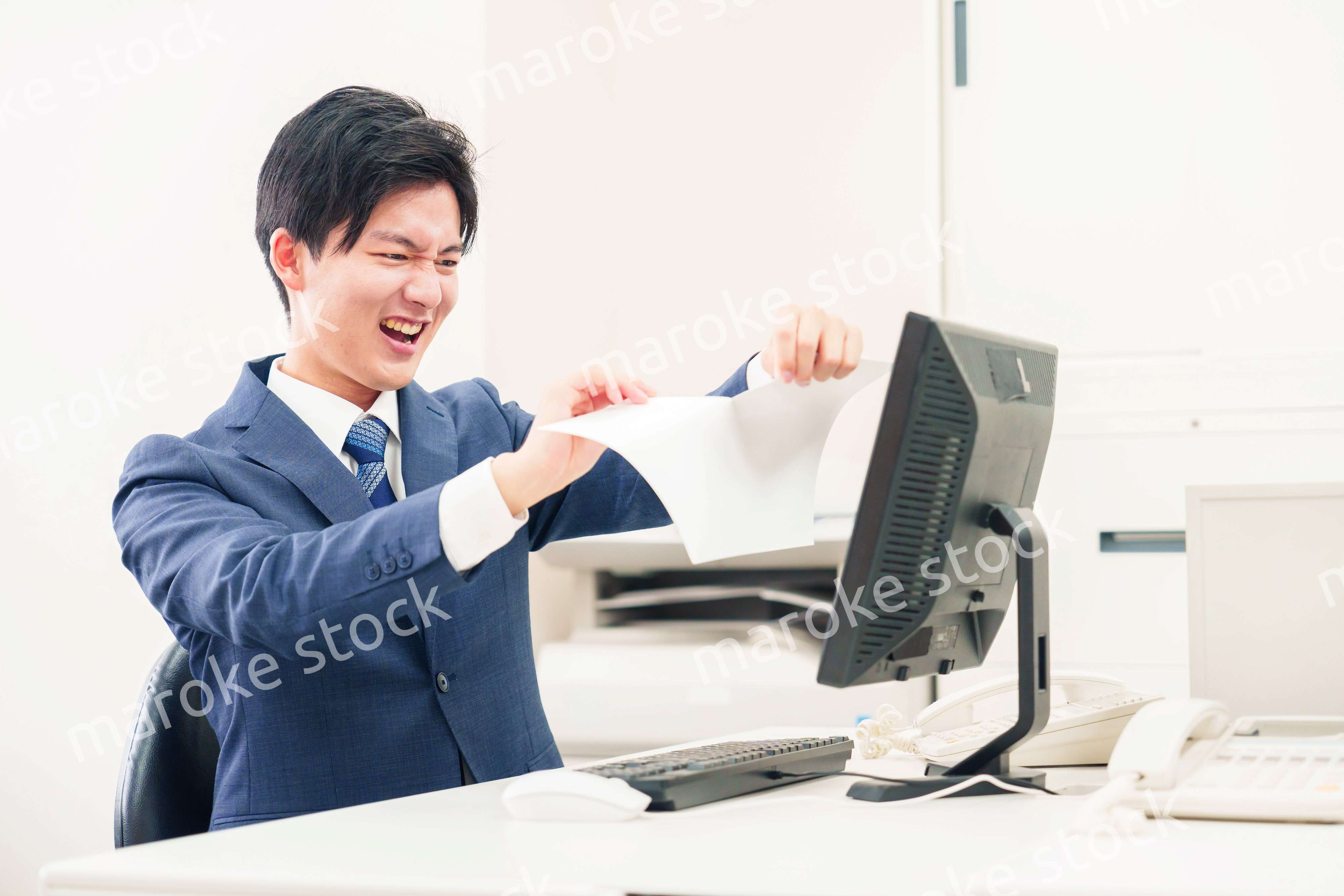 オフィスで書類を破り捨てるビジネスマン