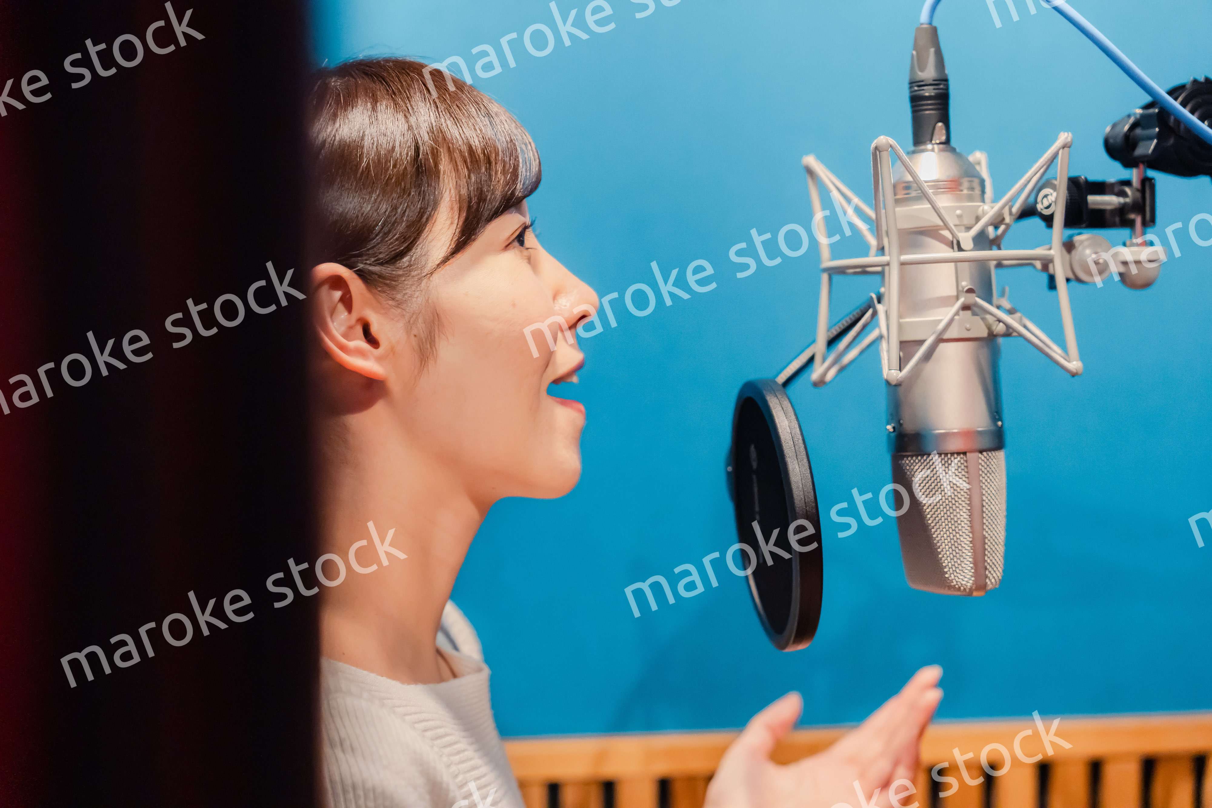 歌の収録をする若い女性