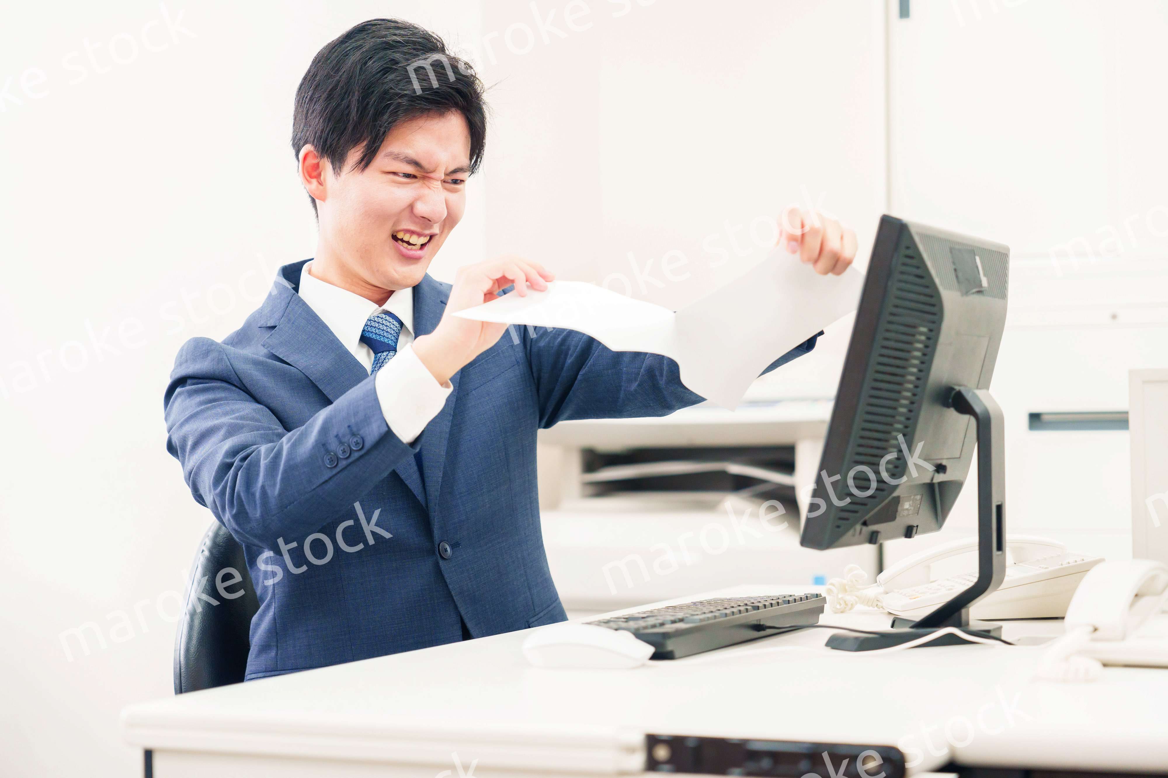 オフィスで書類を破り捨てるビジネスマン