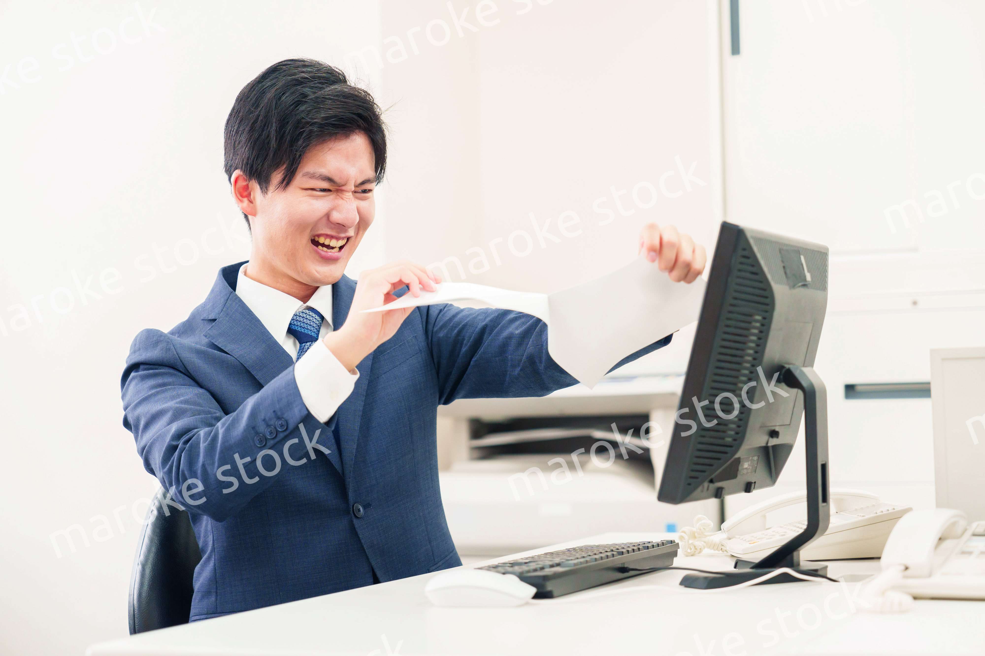 オフィスで書類を破り捨てるビジネスマン