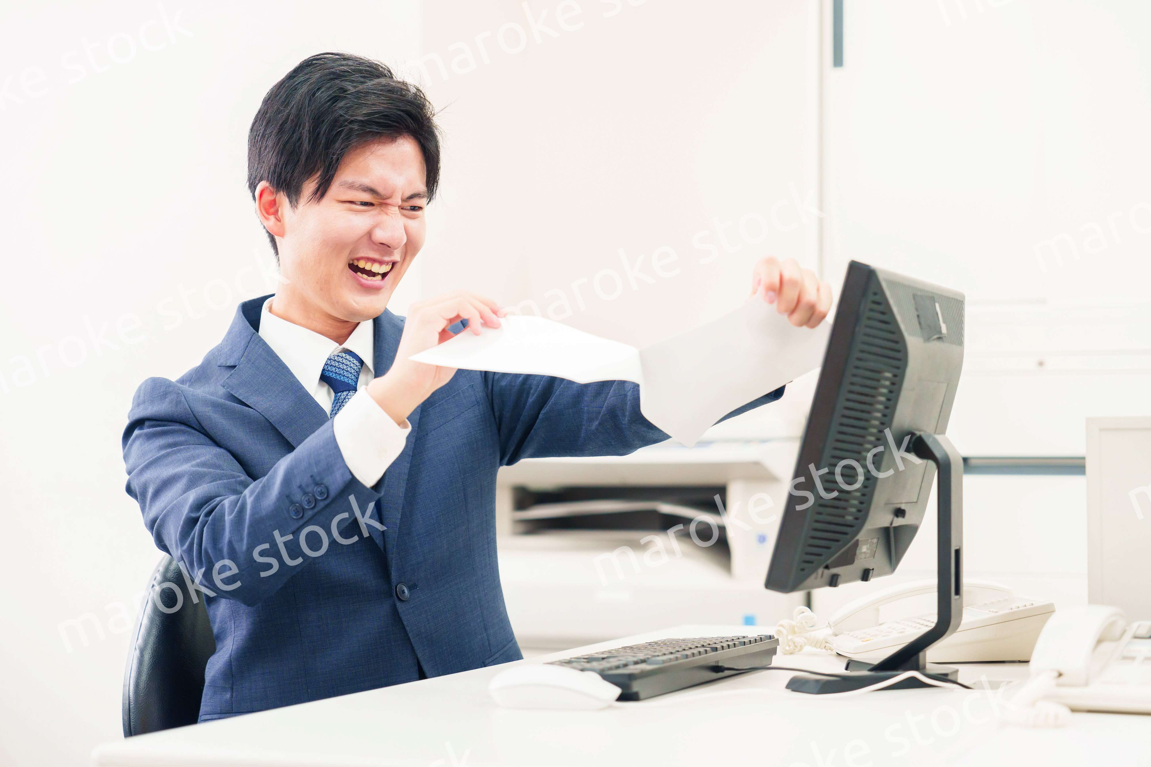 オフィスで書類を破り捨てるビジネスマン