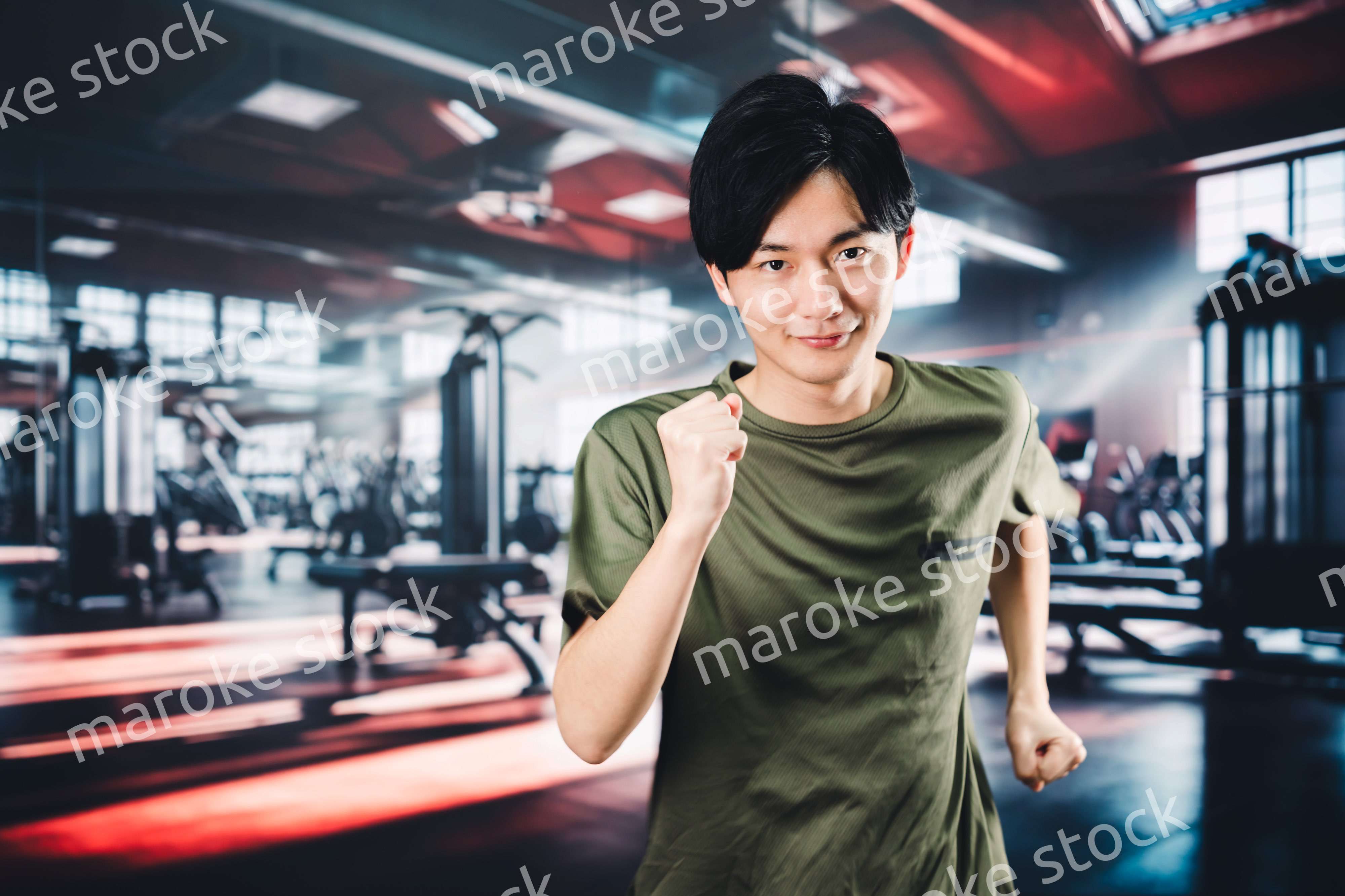 スポーツジムでランニングをする若い男性