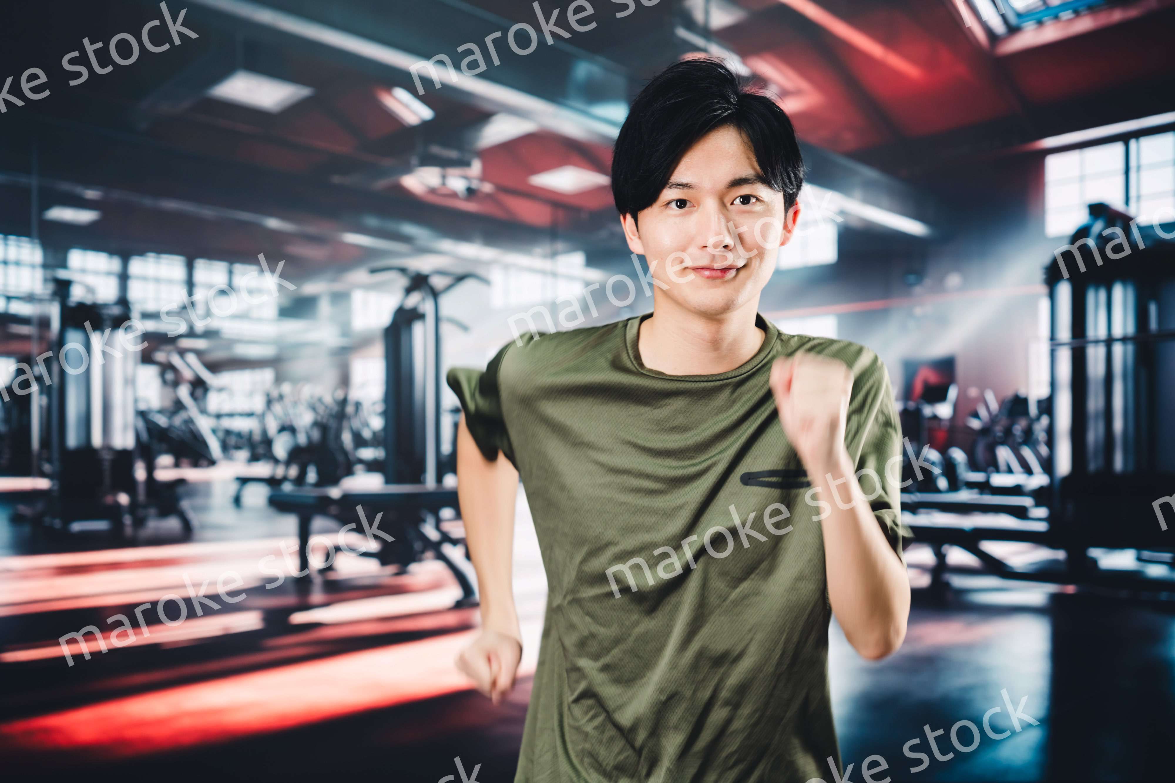 スポーツジムでランニングをする若い男性