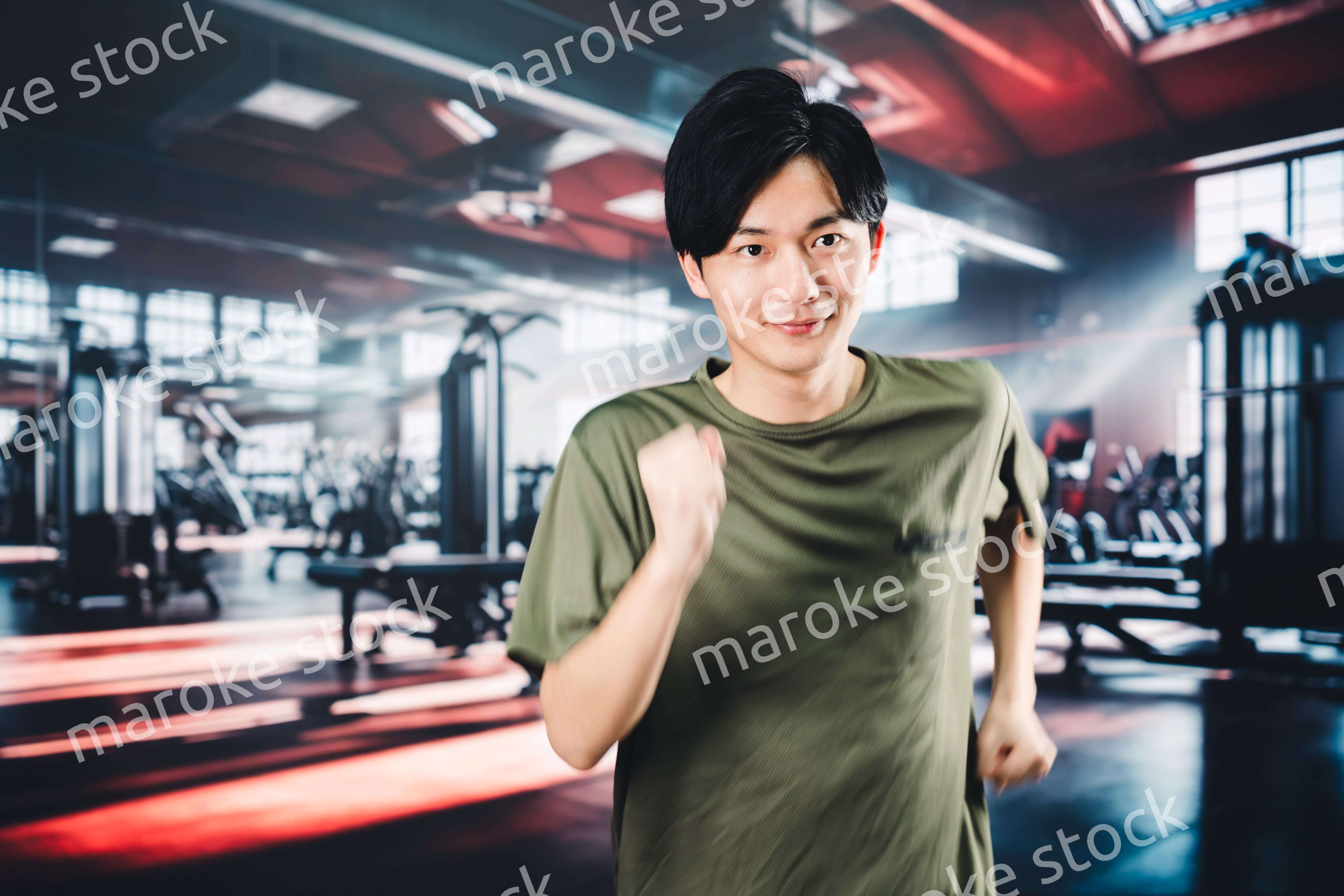 スポーツジムでランニングをする若い男性