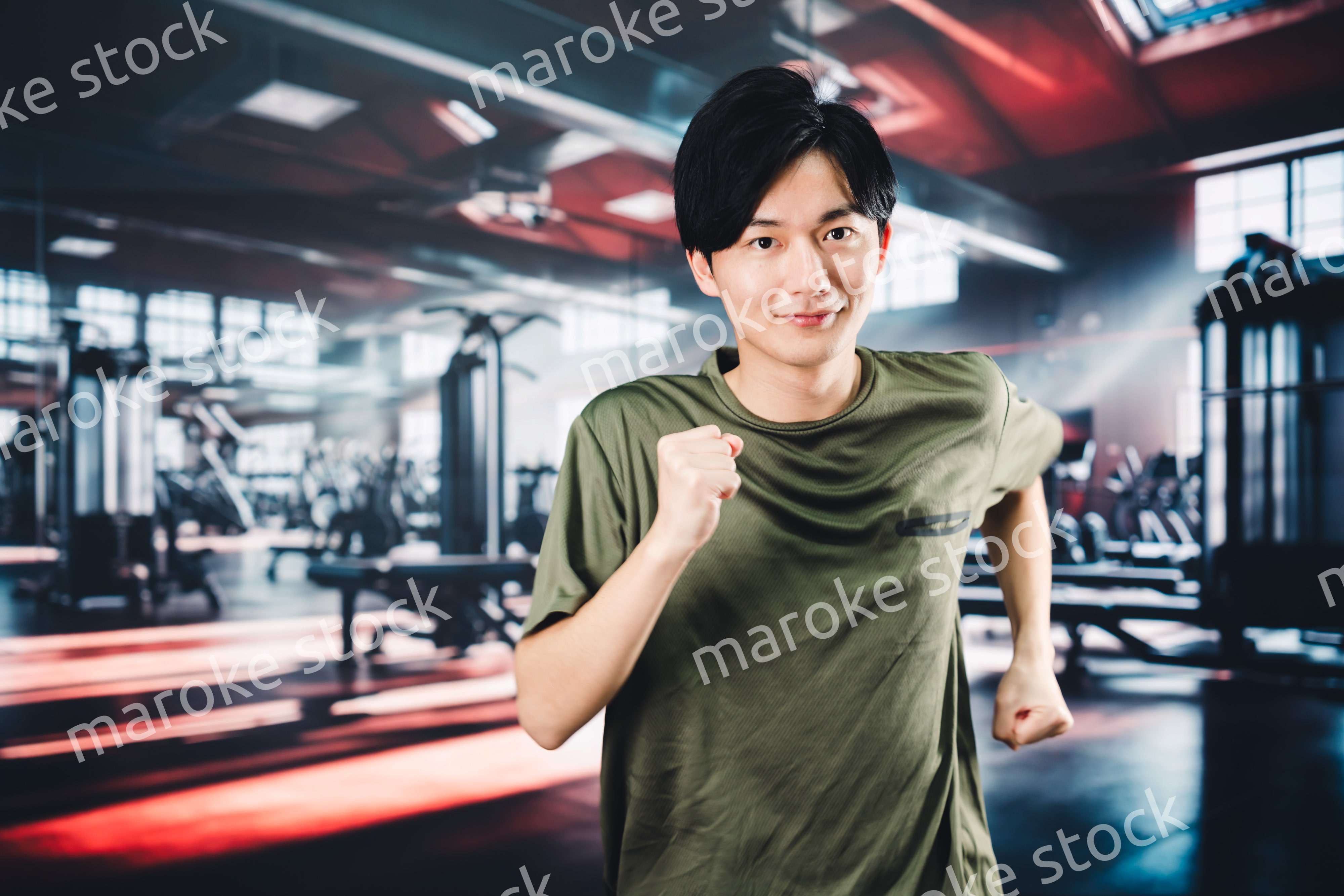 スポーツジムでランニングをする若い男性