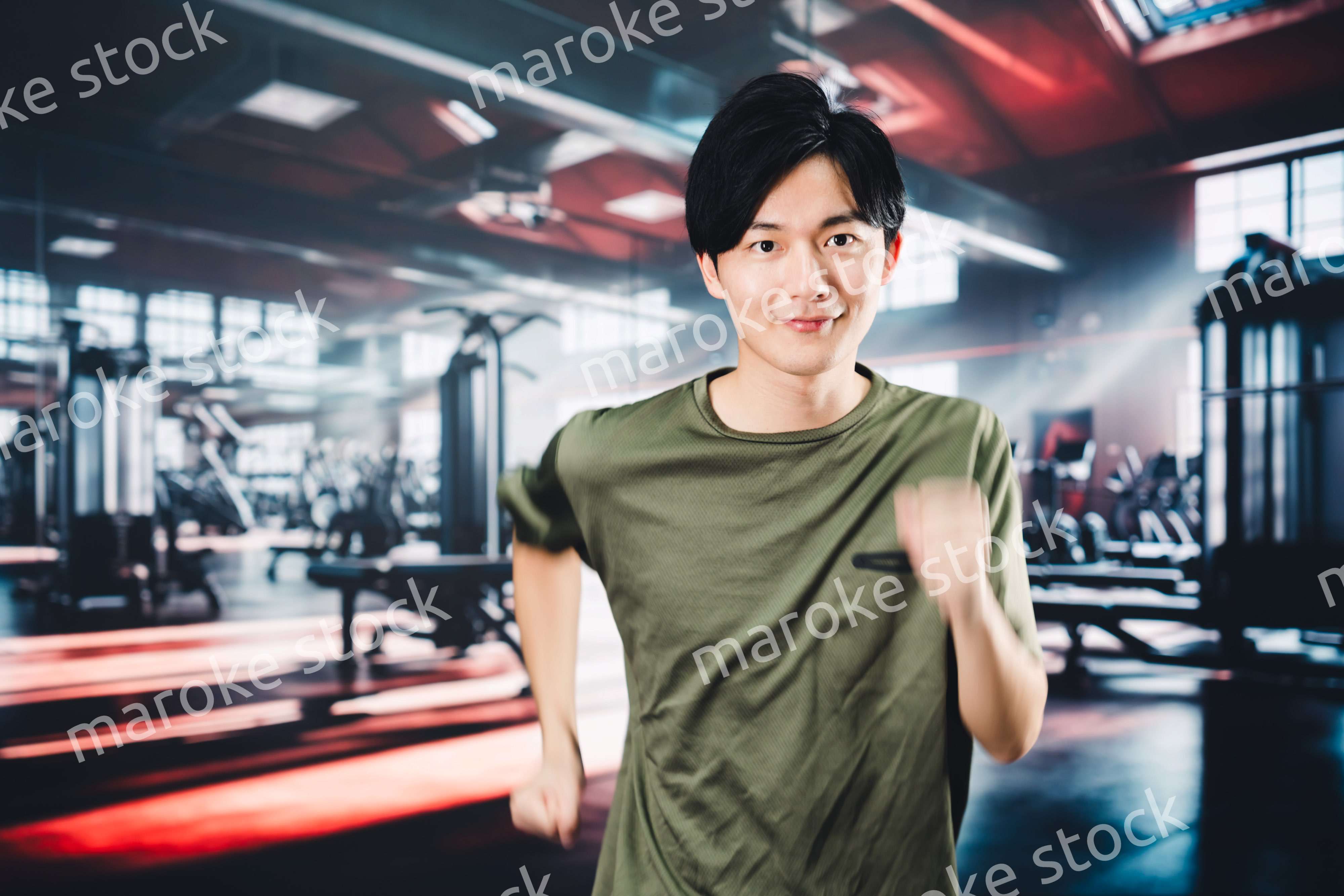 スポーツジムでランニングをする若い男性