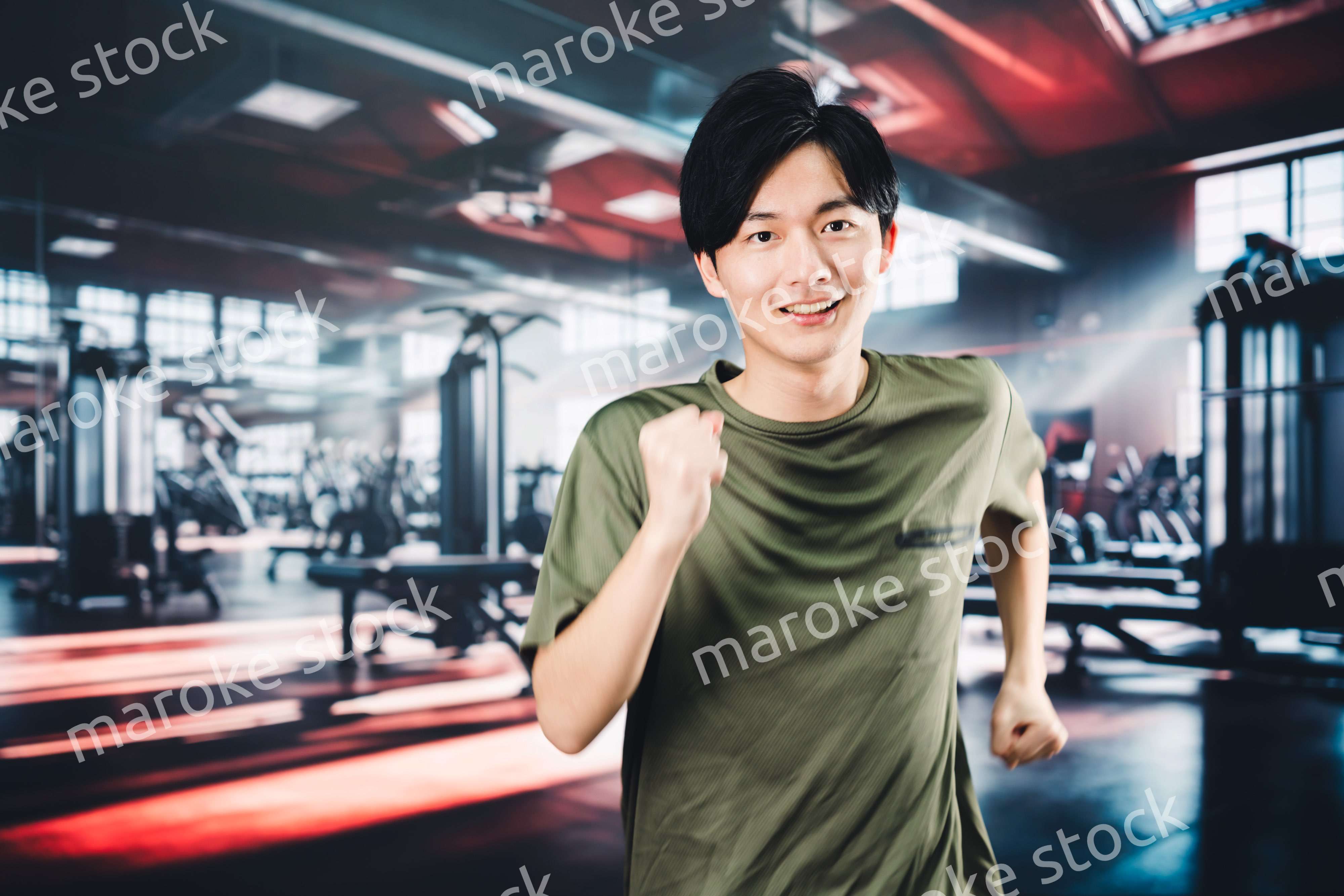 スポーツジムでランニングをする若い男性