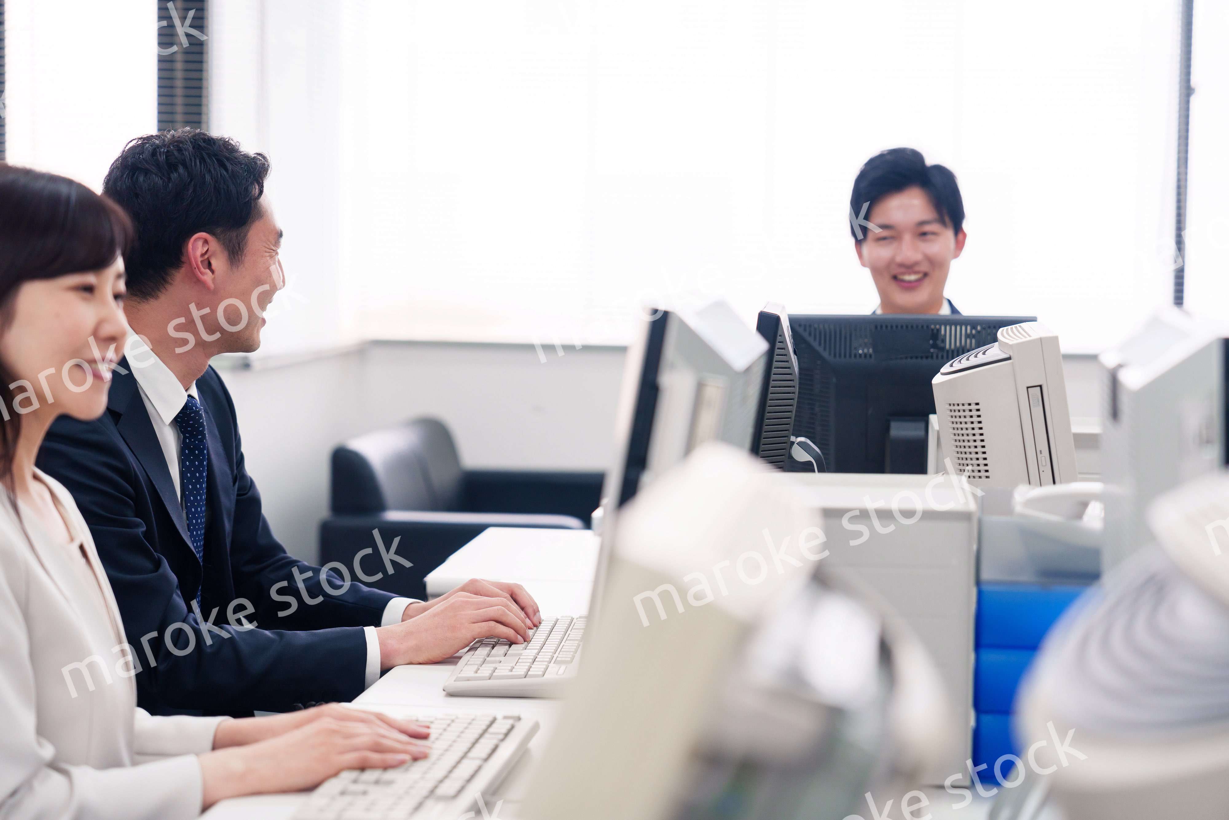 オフィスで働く複数のビジネスパーソン