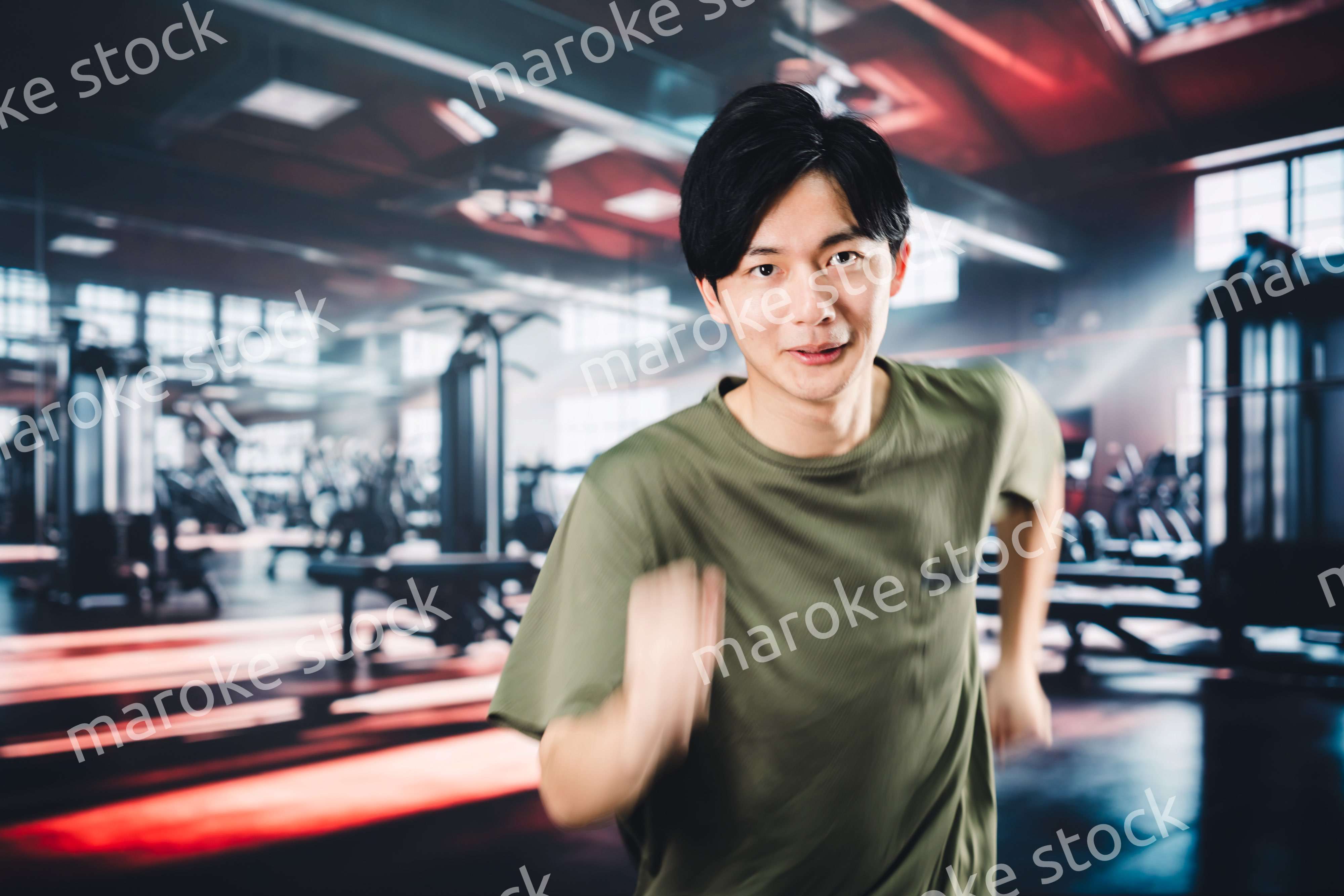 スポーツジムでランニングをする若い男性