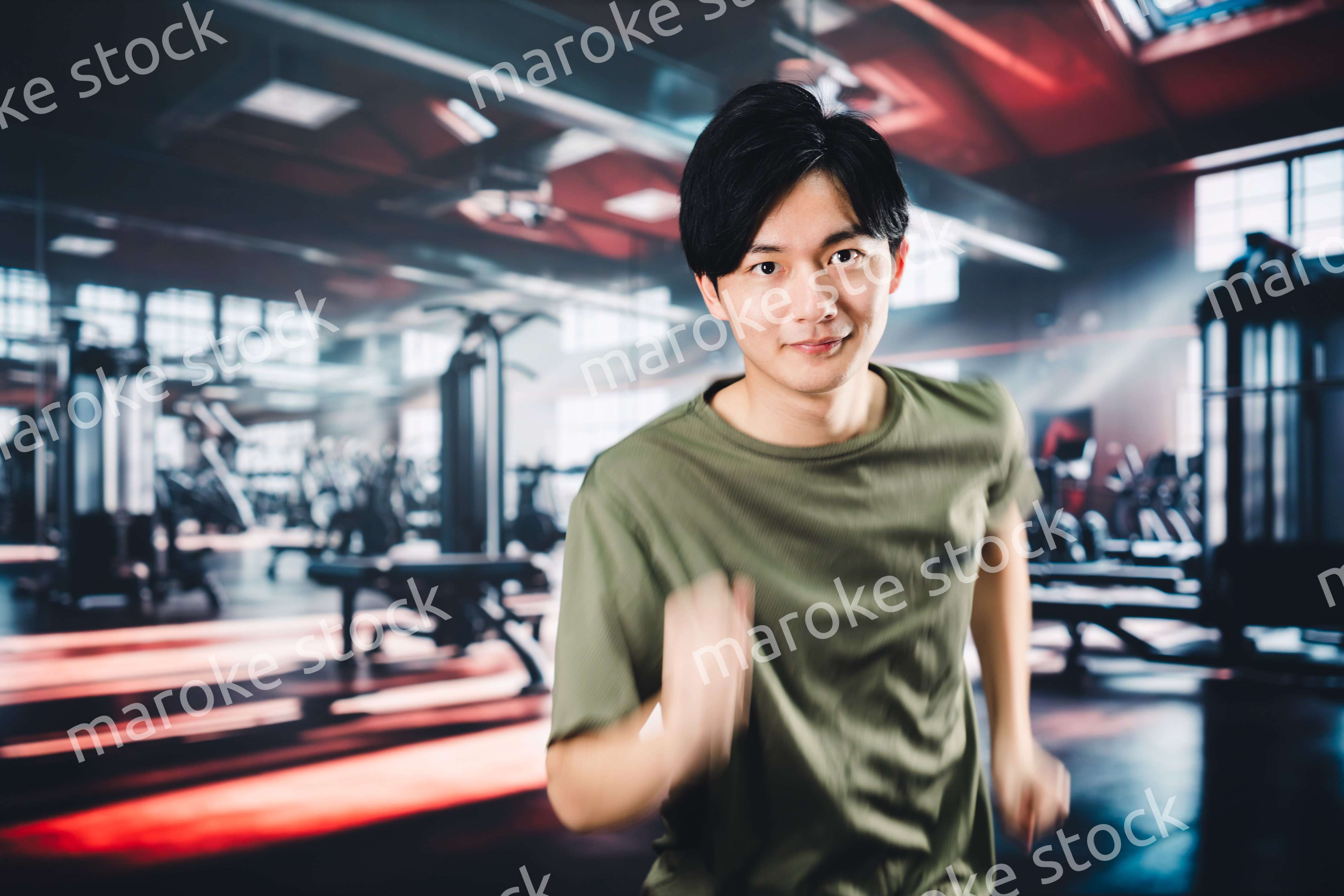 スポーツジムでランニングをする若い男性