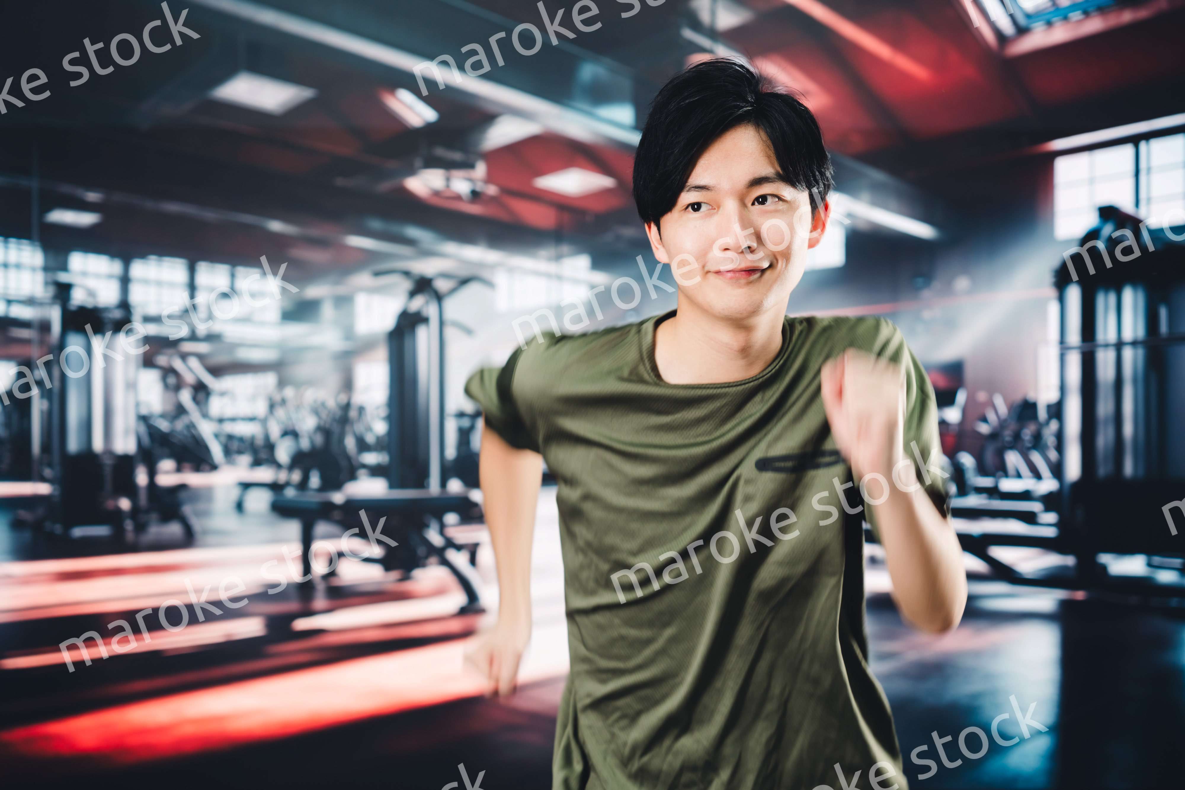 スポーツジムでランニングをする若い男性