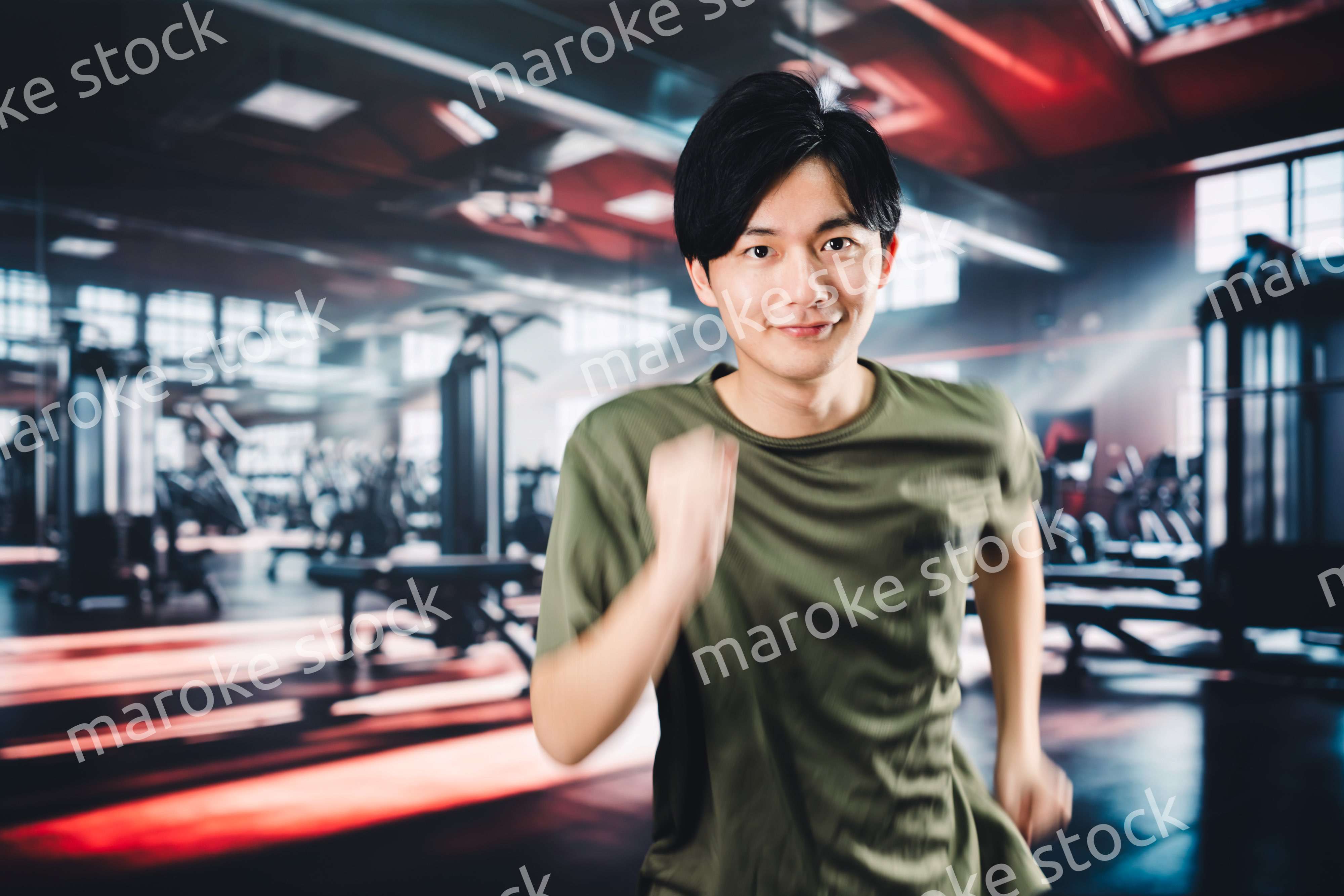 スポーツジムでランニングをする若い男性