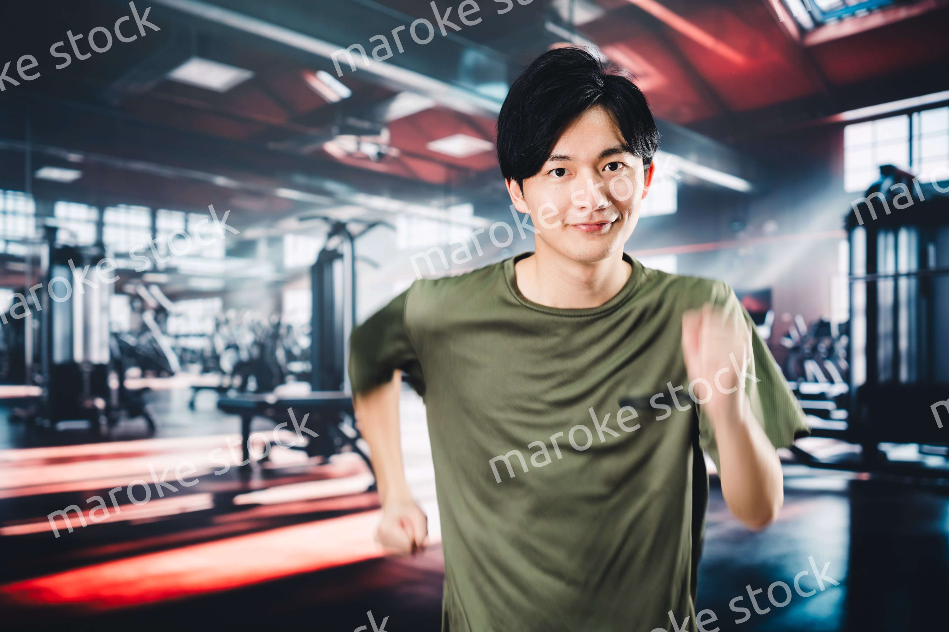 スポーツジムでランニングをする若い男性