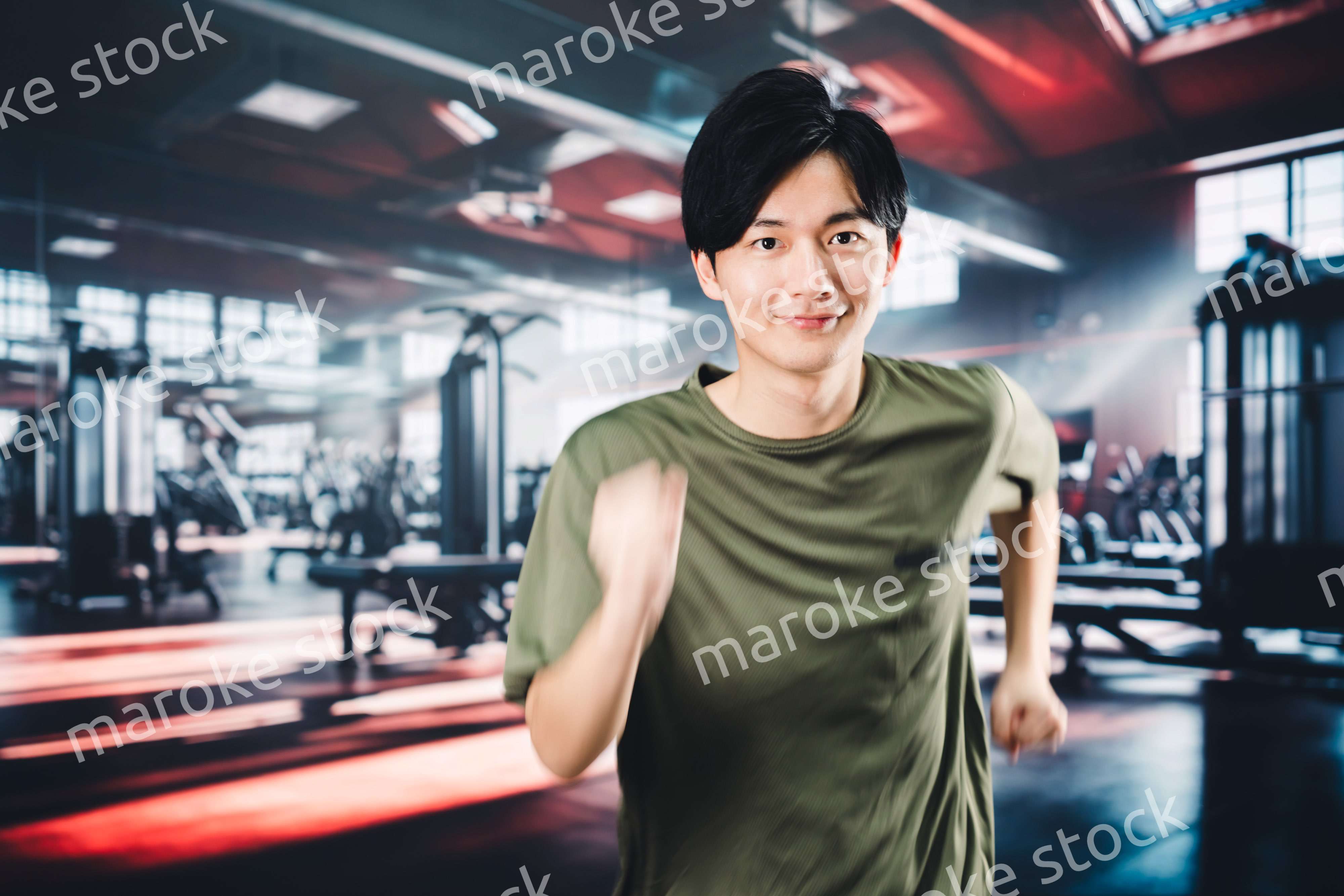 スポーツジムでランニングをする若い男性