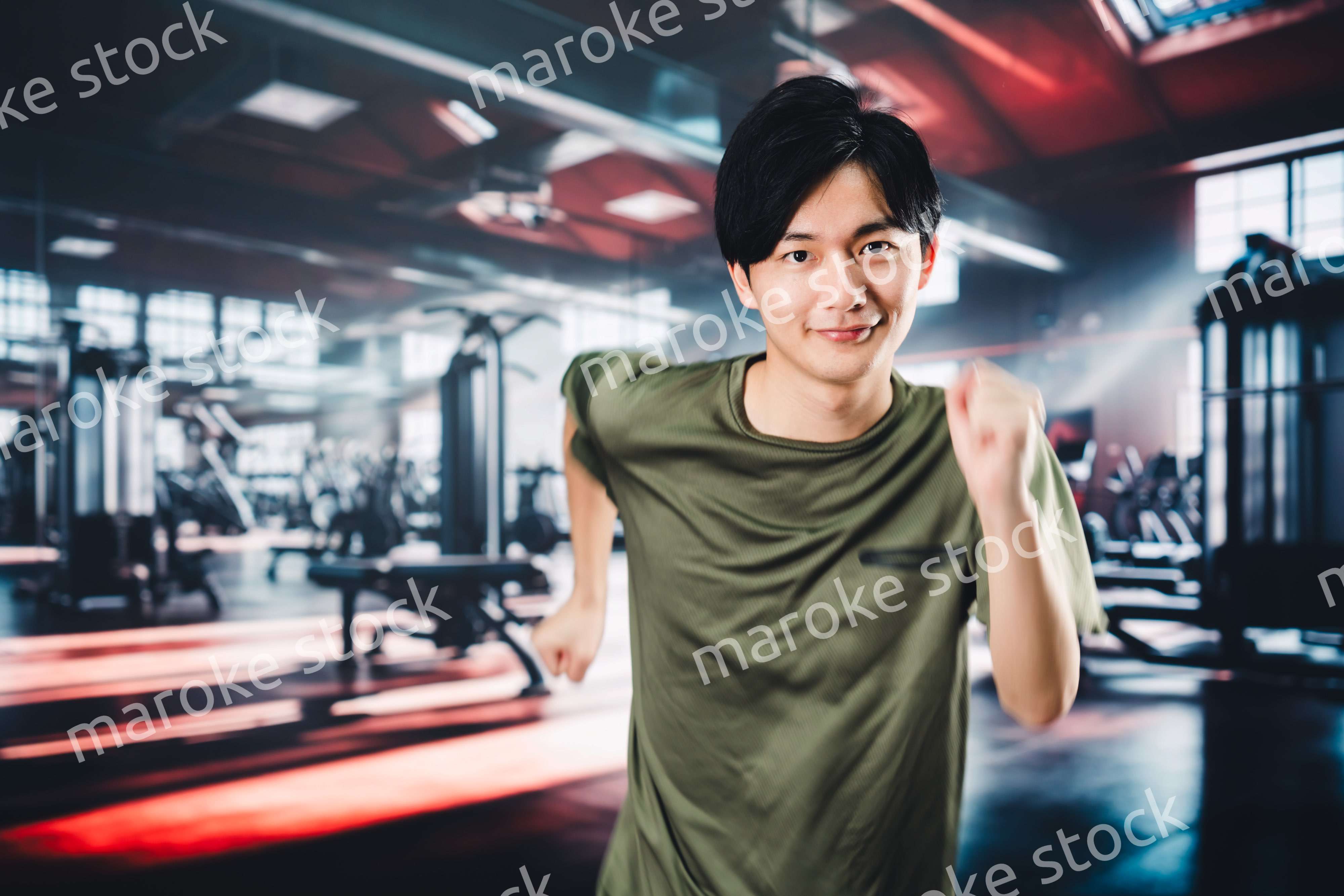 スポーツジムでランニングをする若い男性