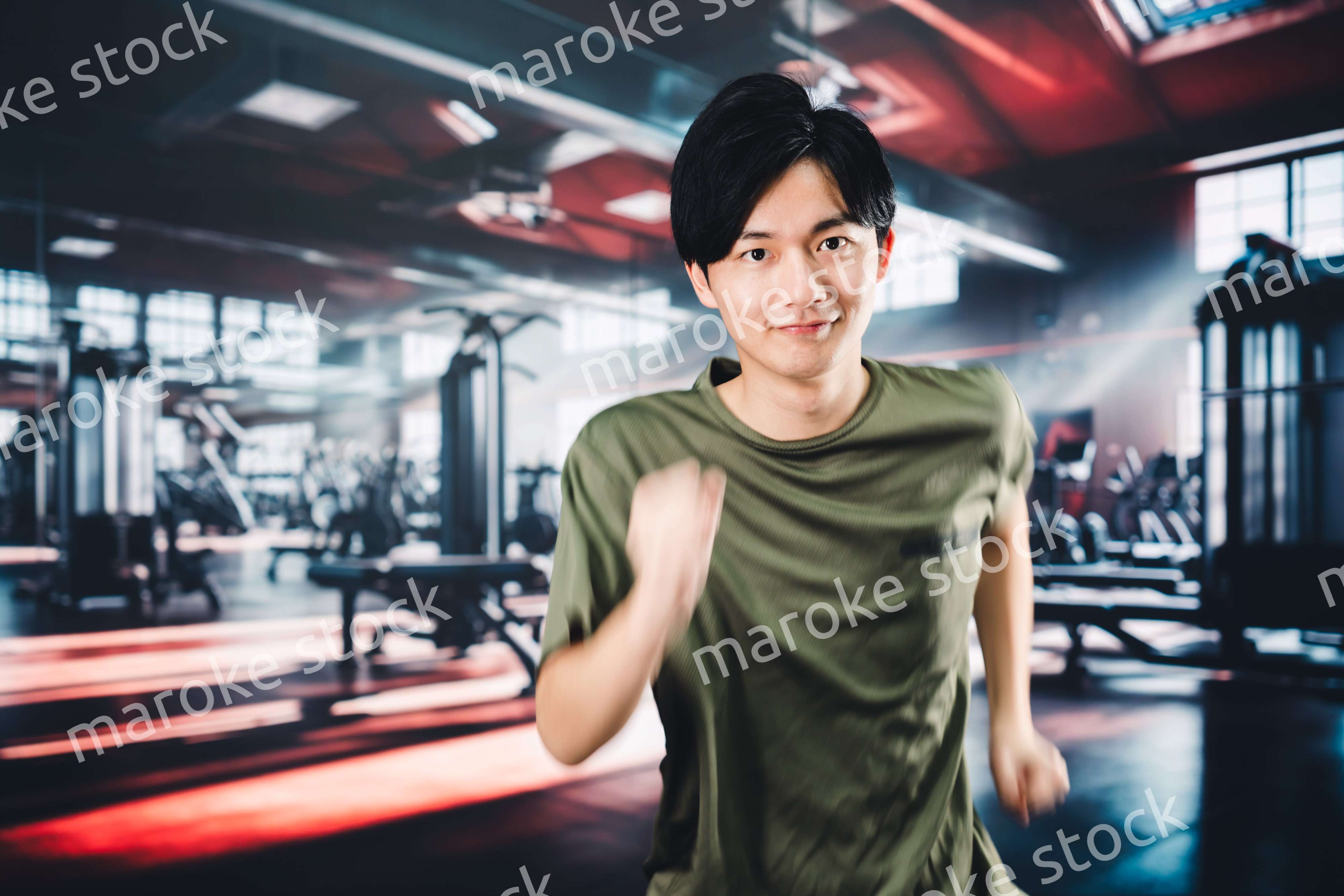 スポーツジムでランニングをする若い男性