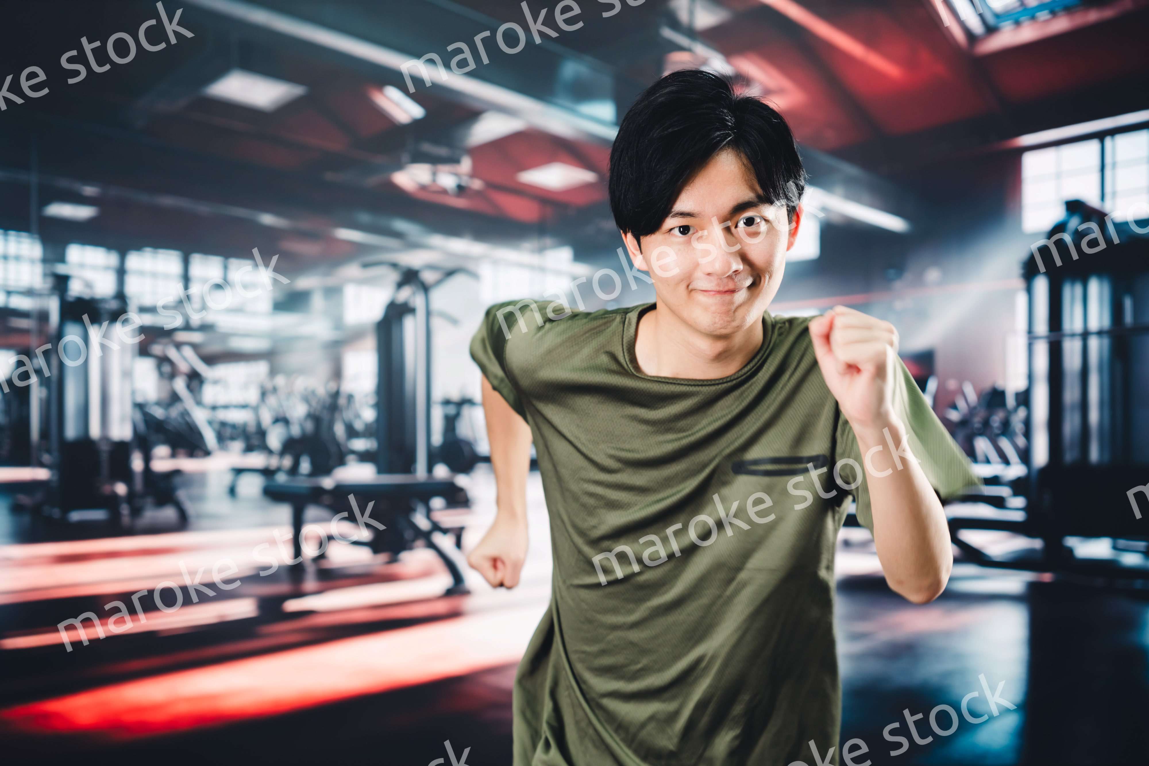 スポーツジムでランニングをする若い男性