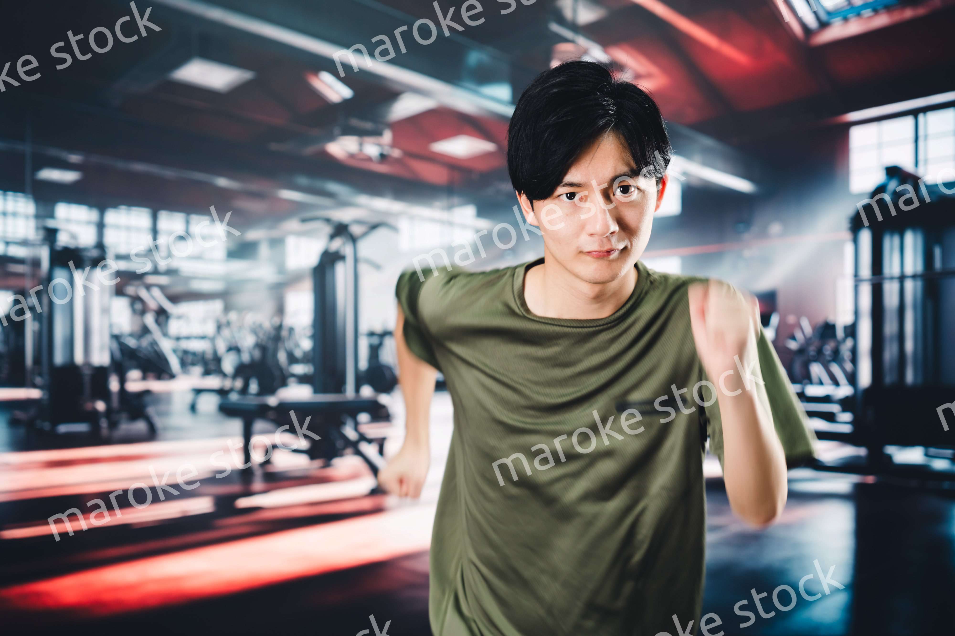 スポーツジムでランニングをする若い男性