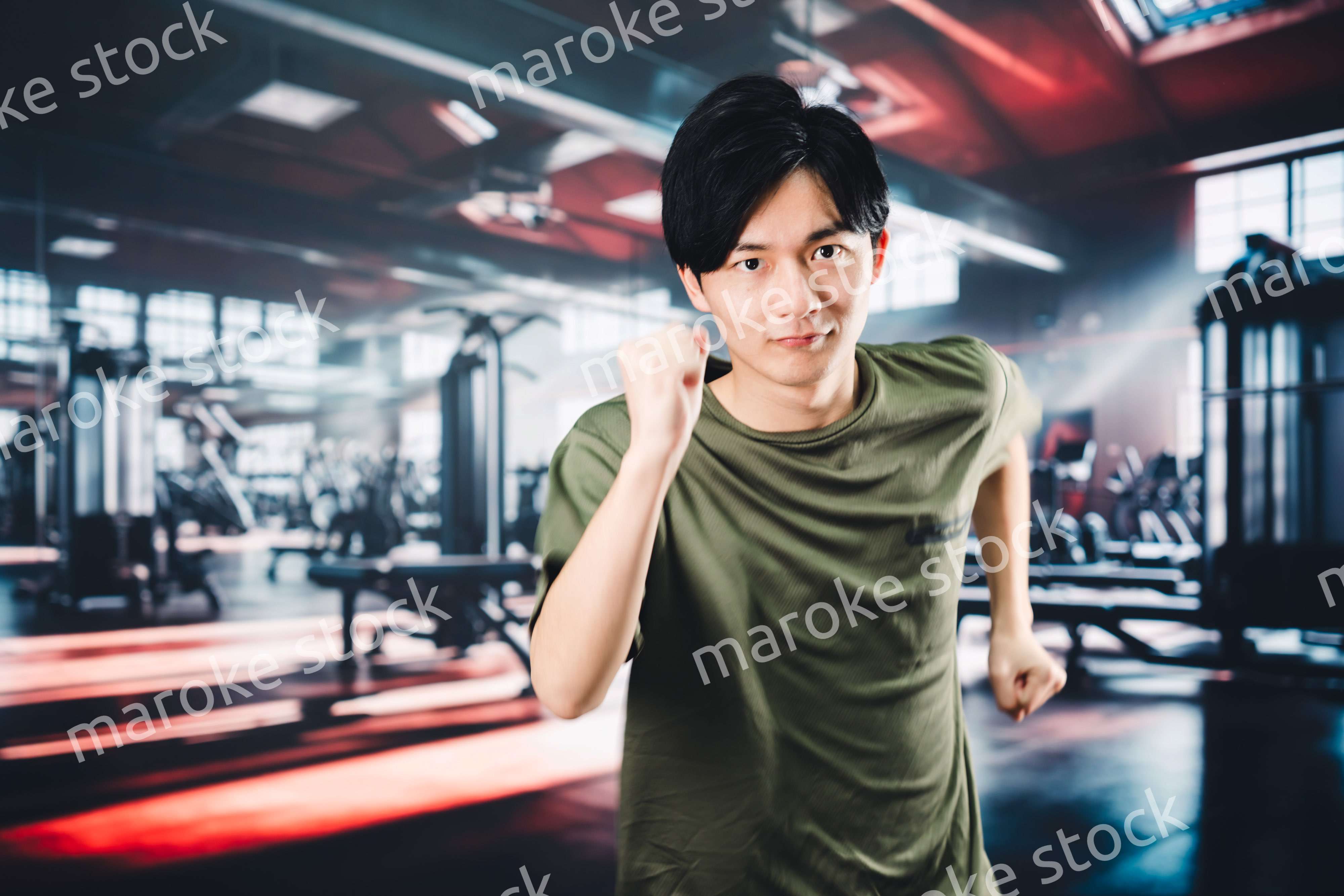 スポーツジムでランニングをする若い男性