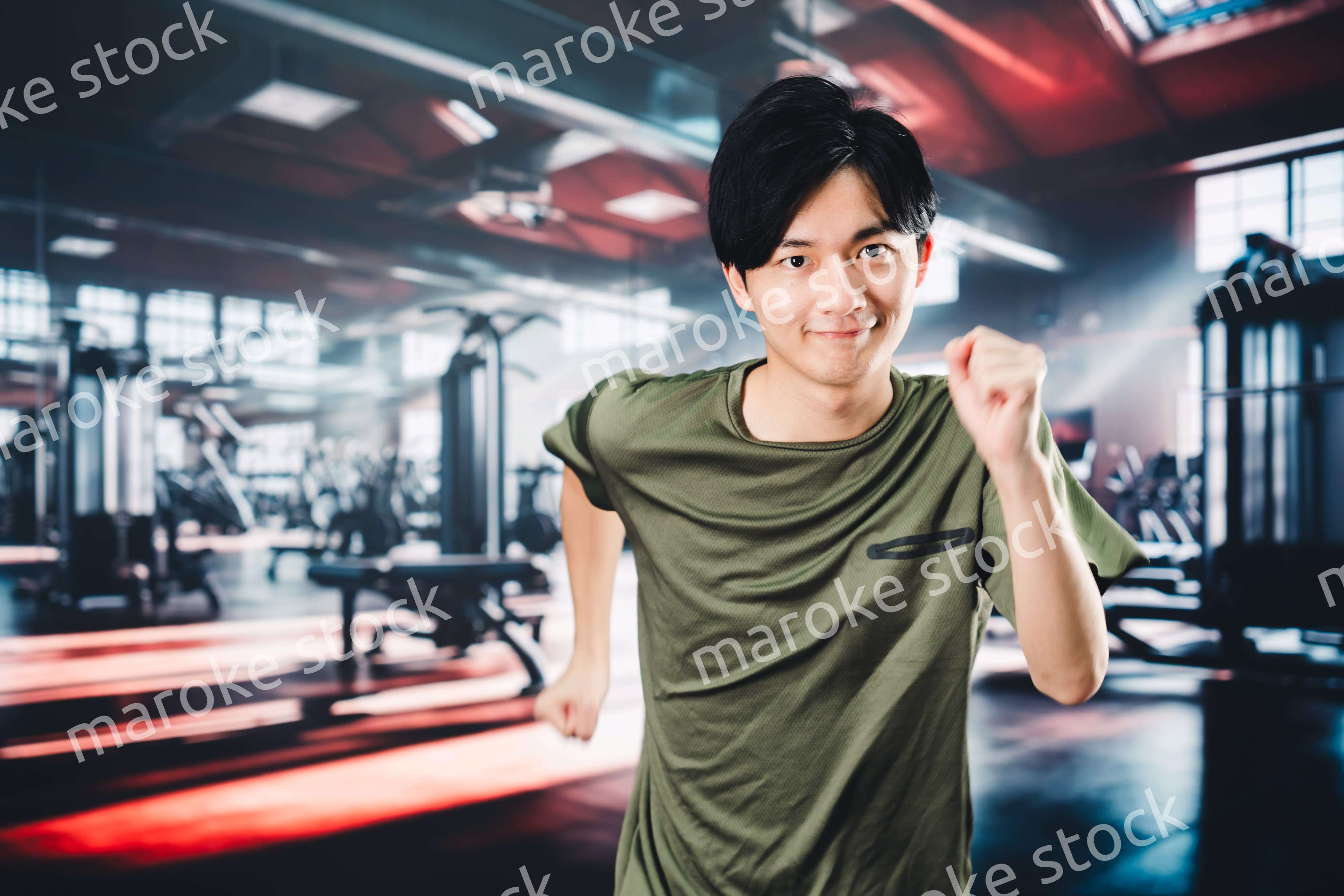 スポーツジムでランニングをする若い男性