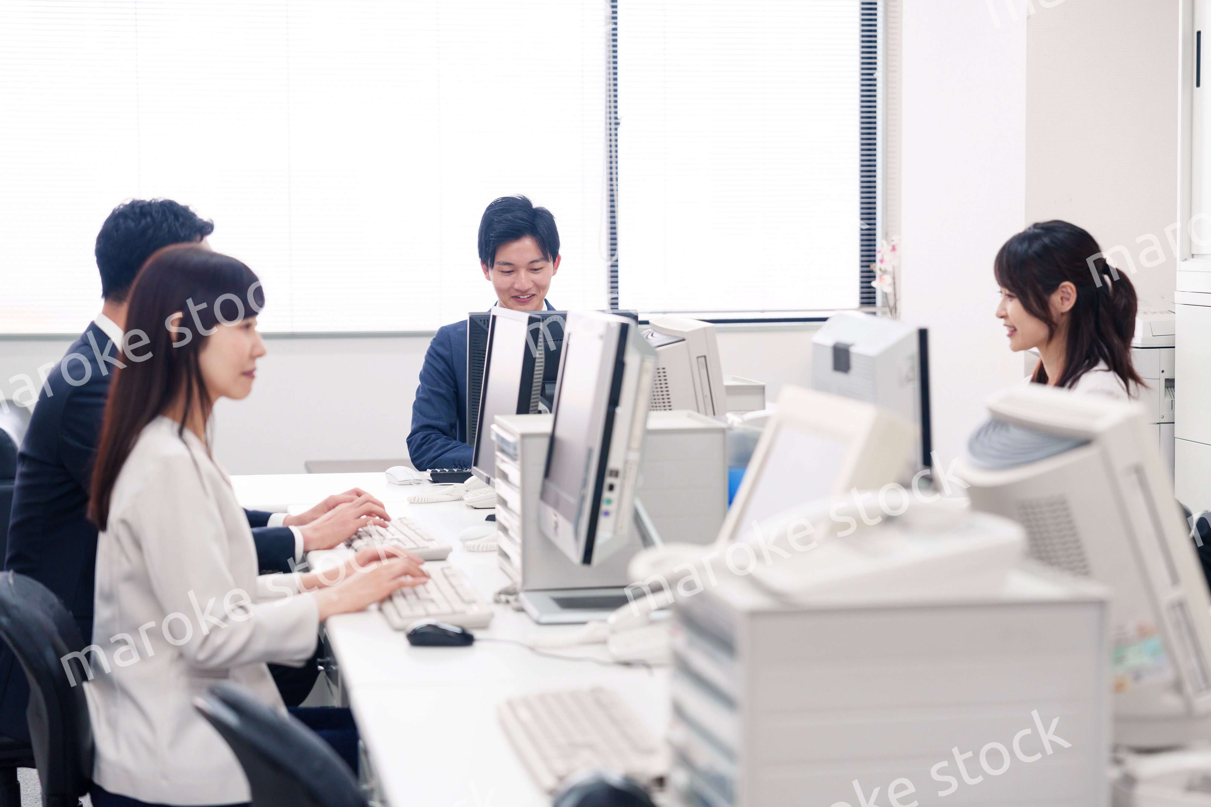 オフィスで働く複数のビジネスパーソン