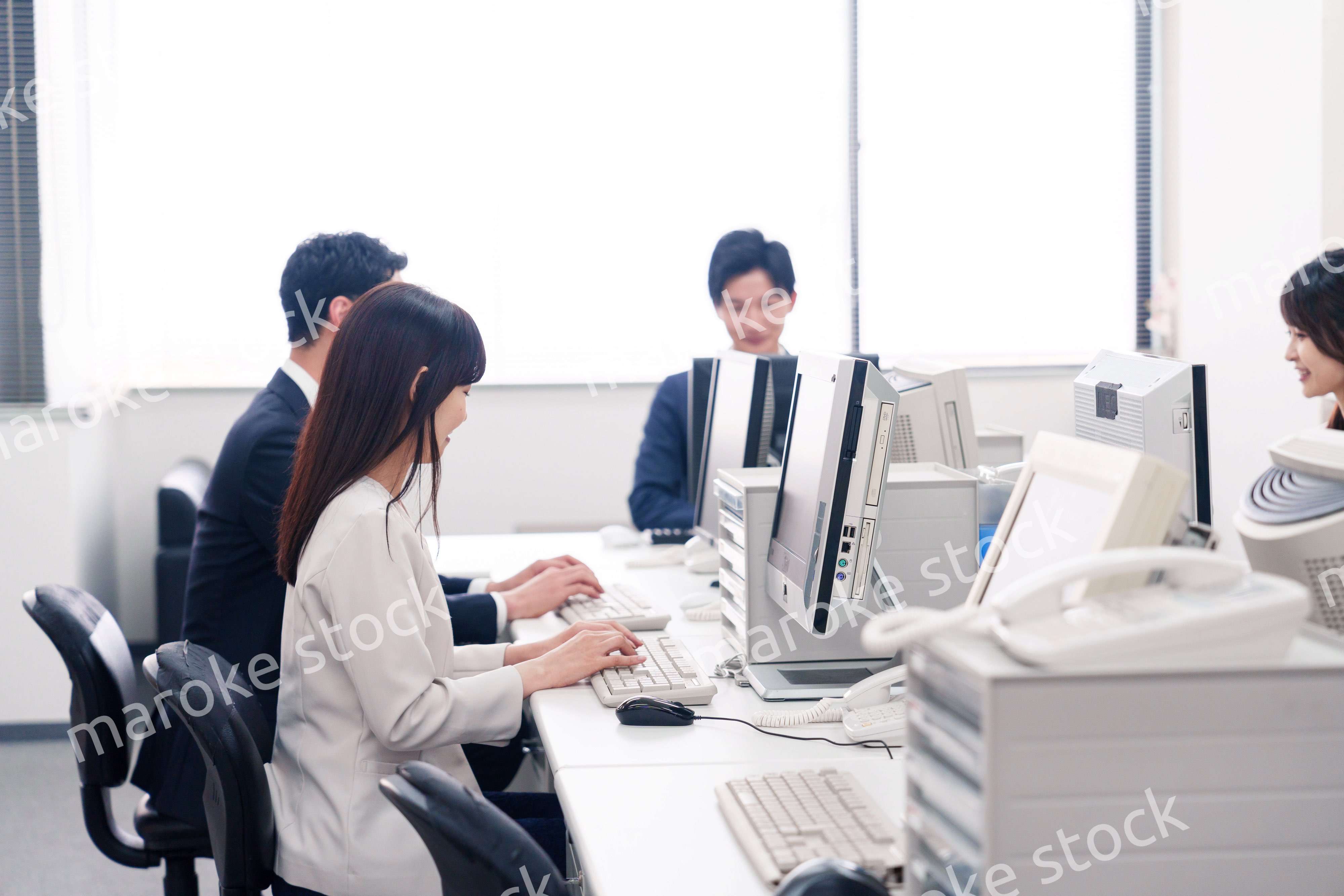 オフィスで働く複数のビジネスパーソン