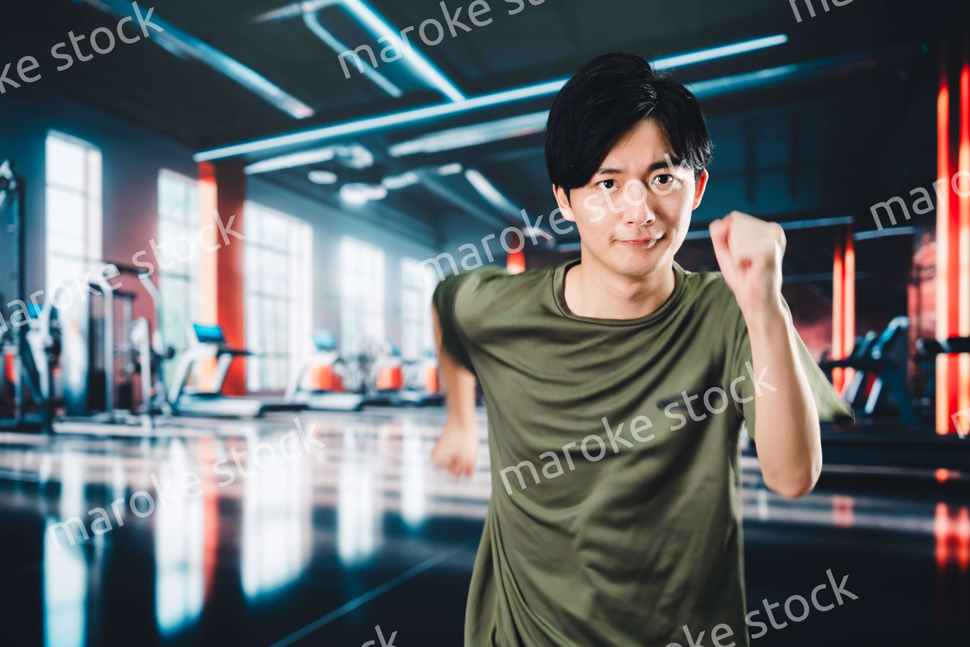 スポーツジムでランニングをする若い男性