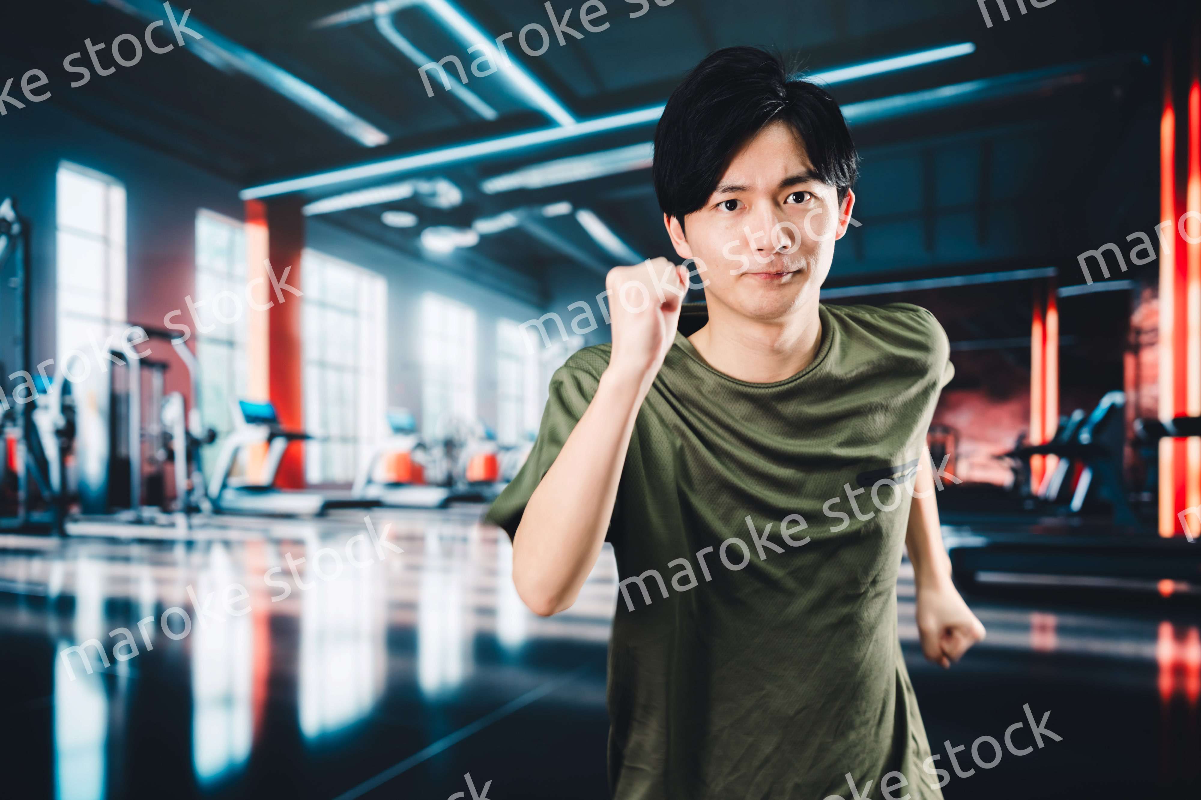 スポーツジムでランニングをする若い男性