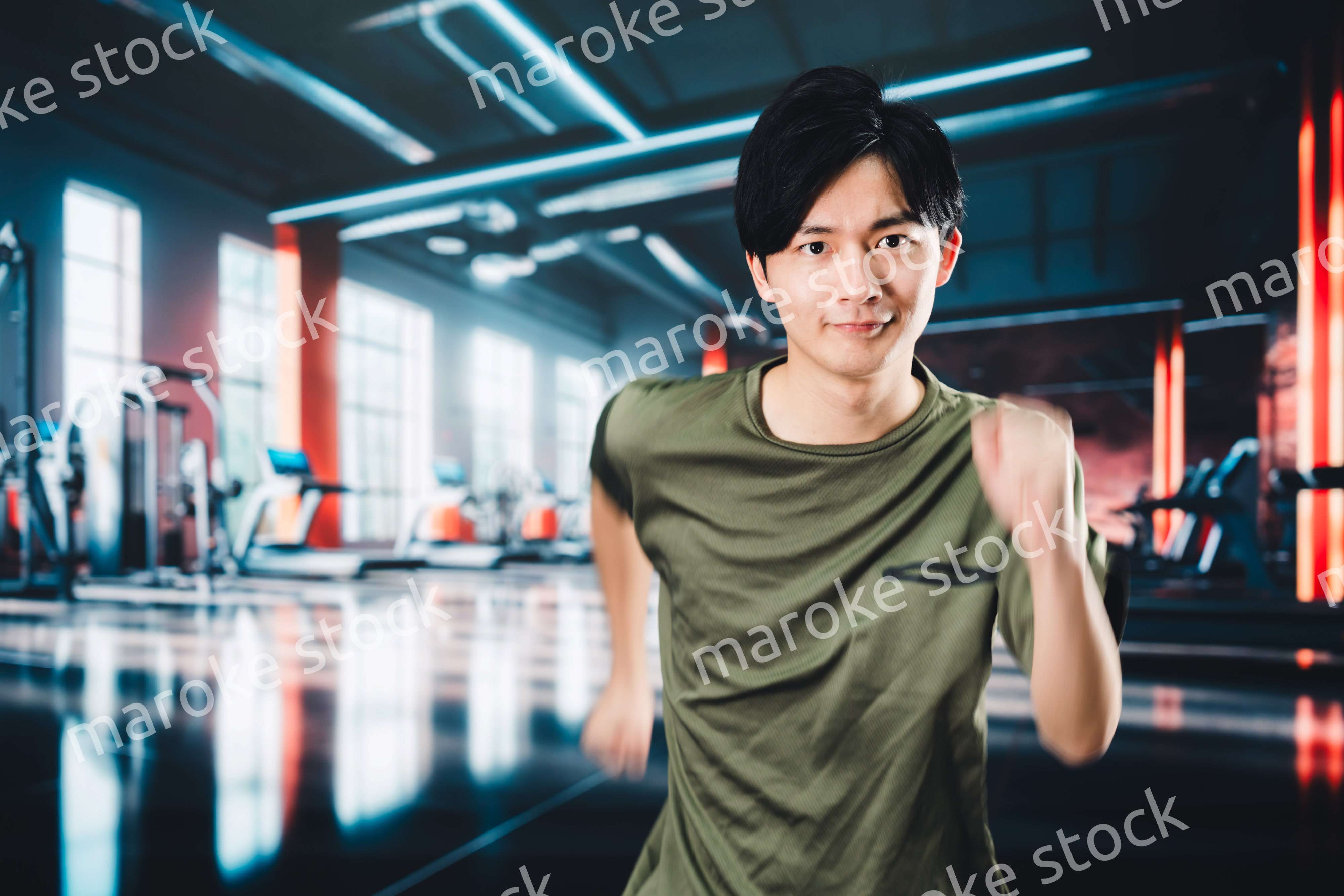 スポーツジムでランニングをする若い男性