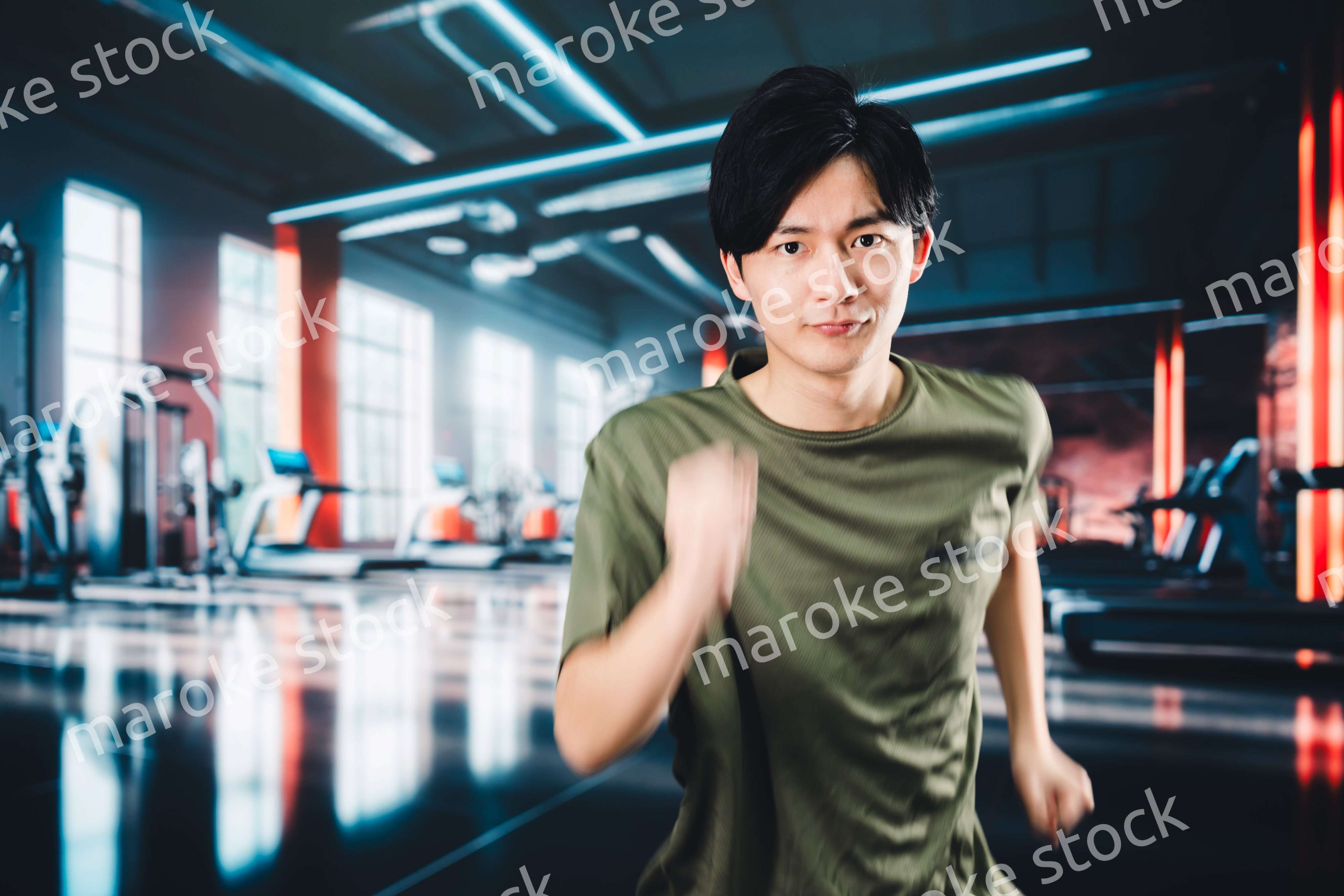 スポーツジムでランニングをする若い男性