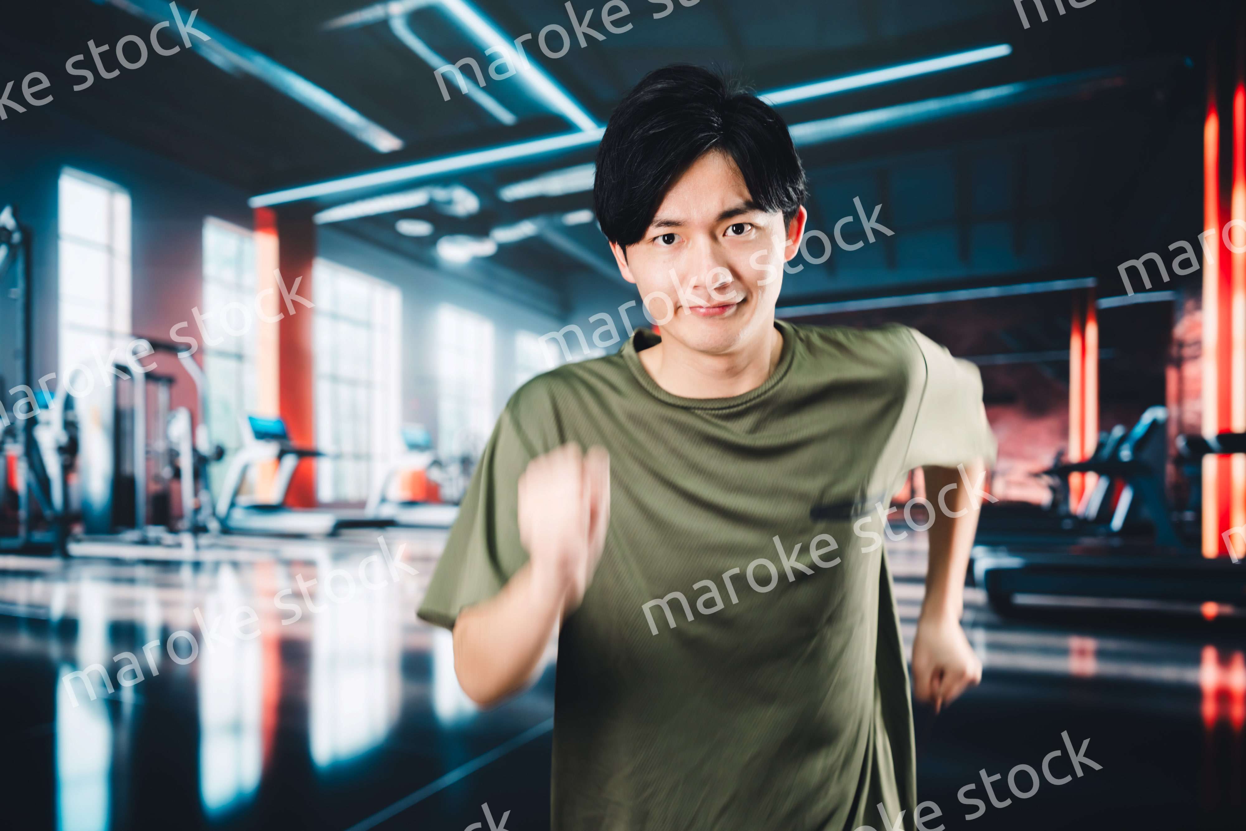 スポーツジムでランニングをする若い男性