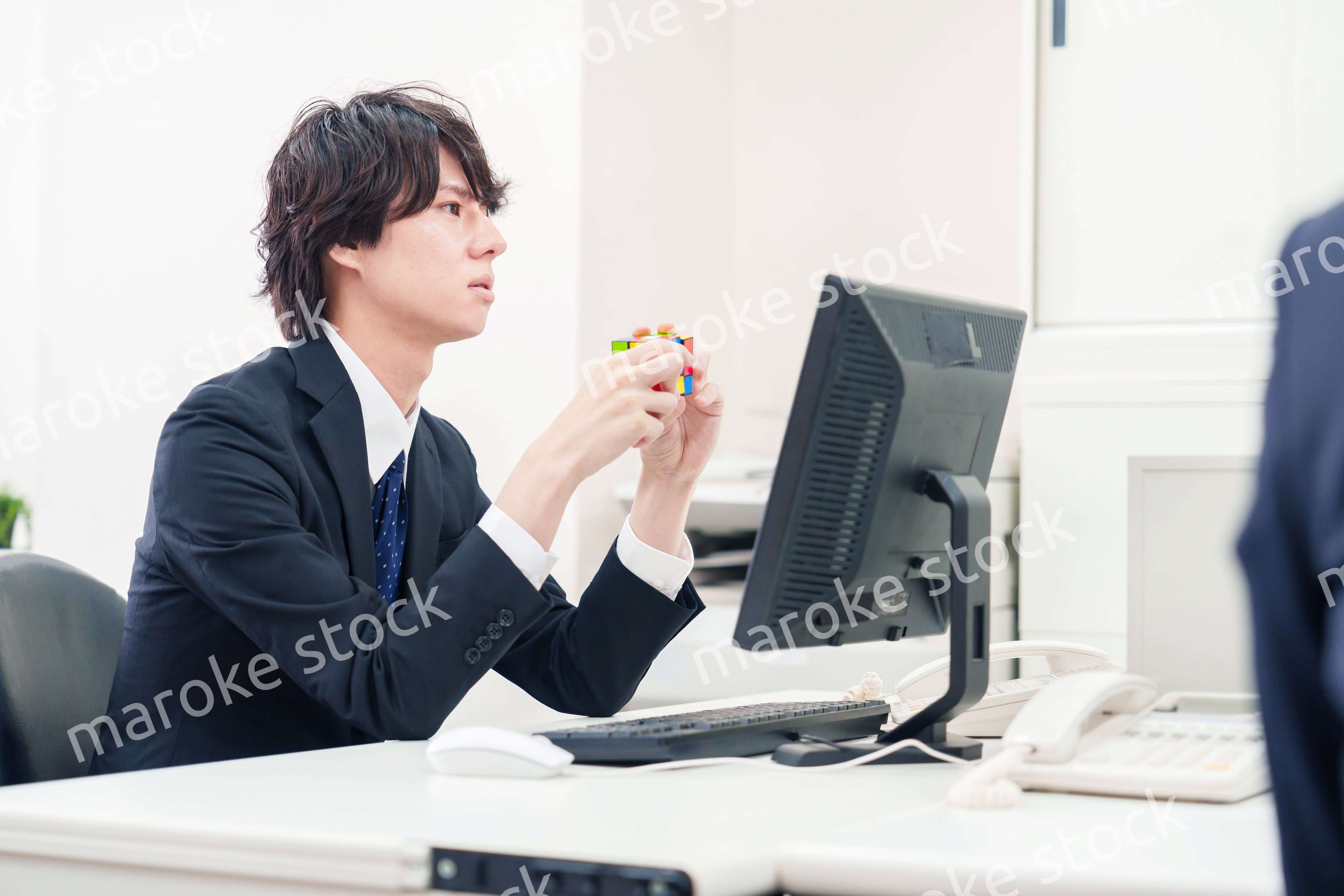 仕事中にルービックキューブをするビジネスマン