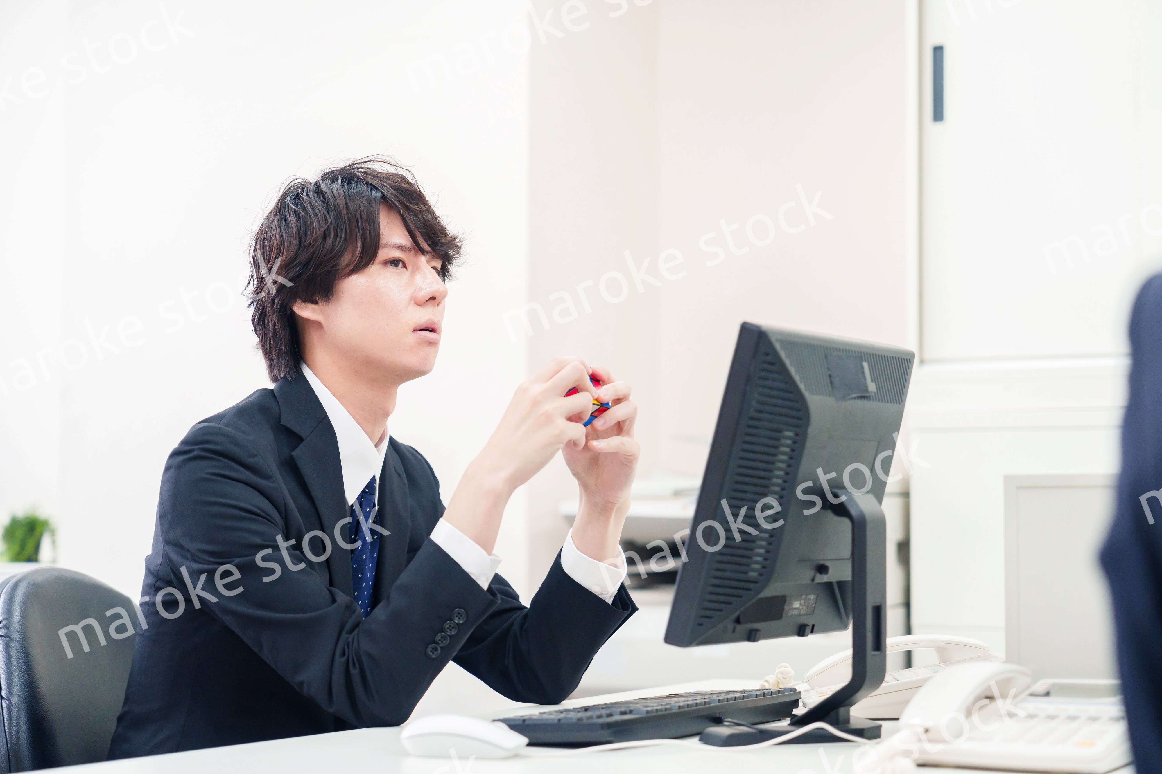 仕事中にルービックキューブをするビジネスマン