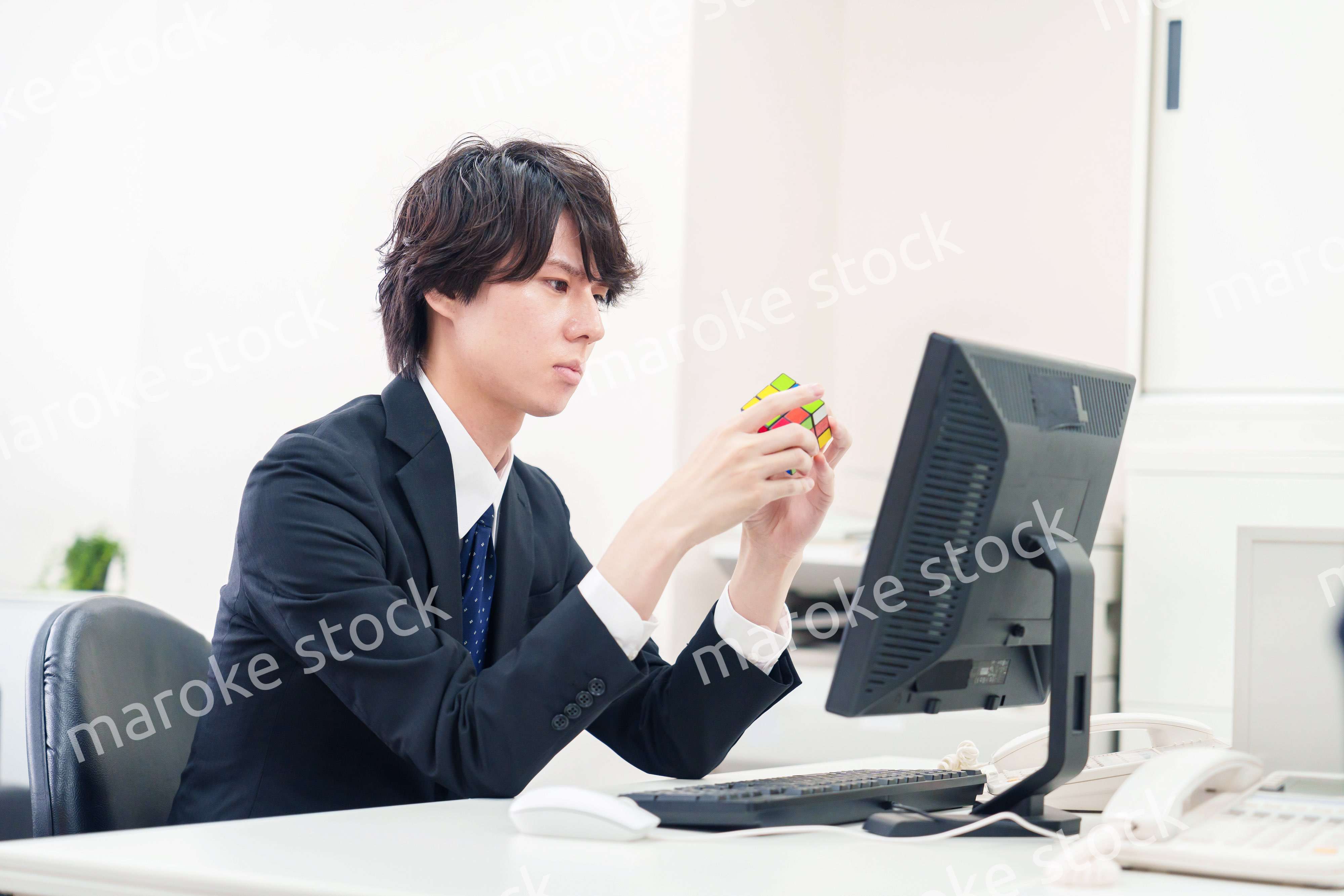 仕事中にルービックキューブをするビジネスマン