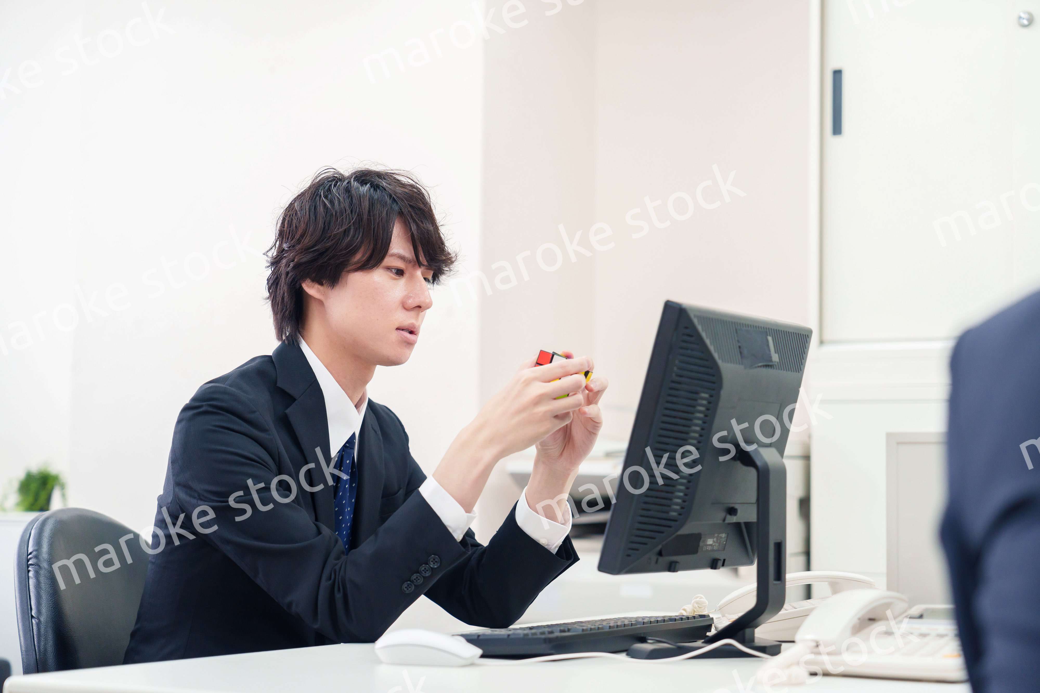 仕事中にルービックキューブをするビジネスマン