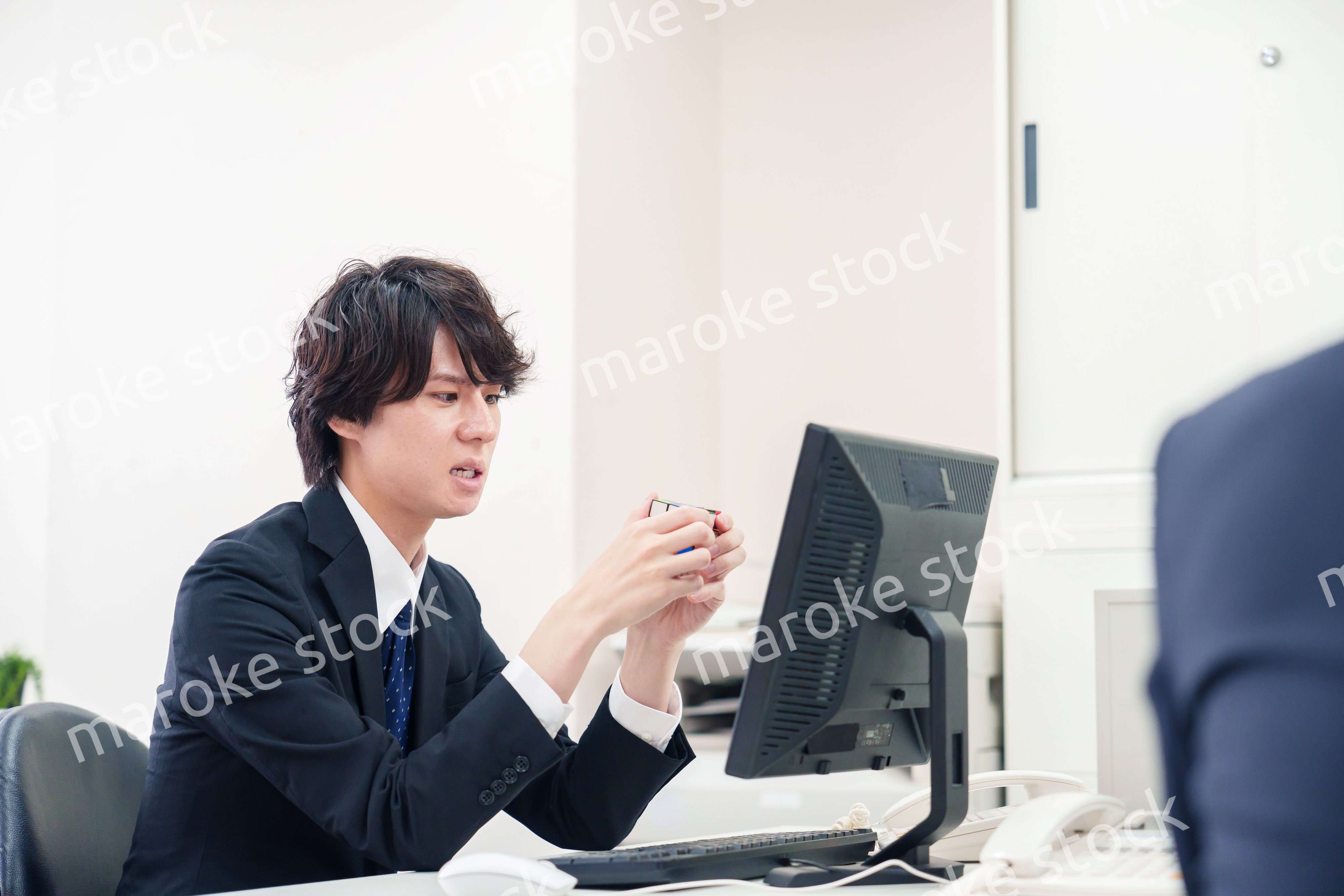 仕事中にルービックキューブをするビジネスマン