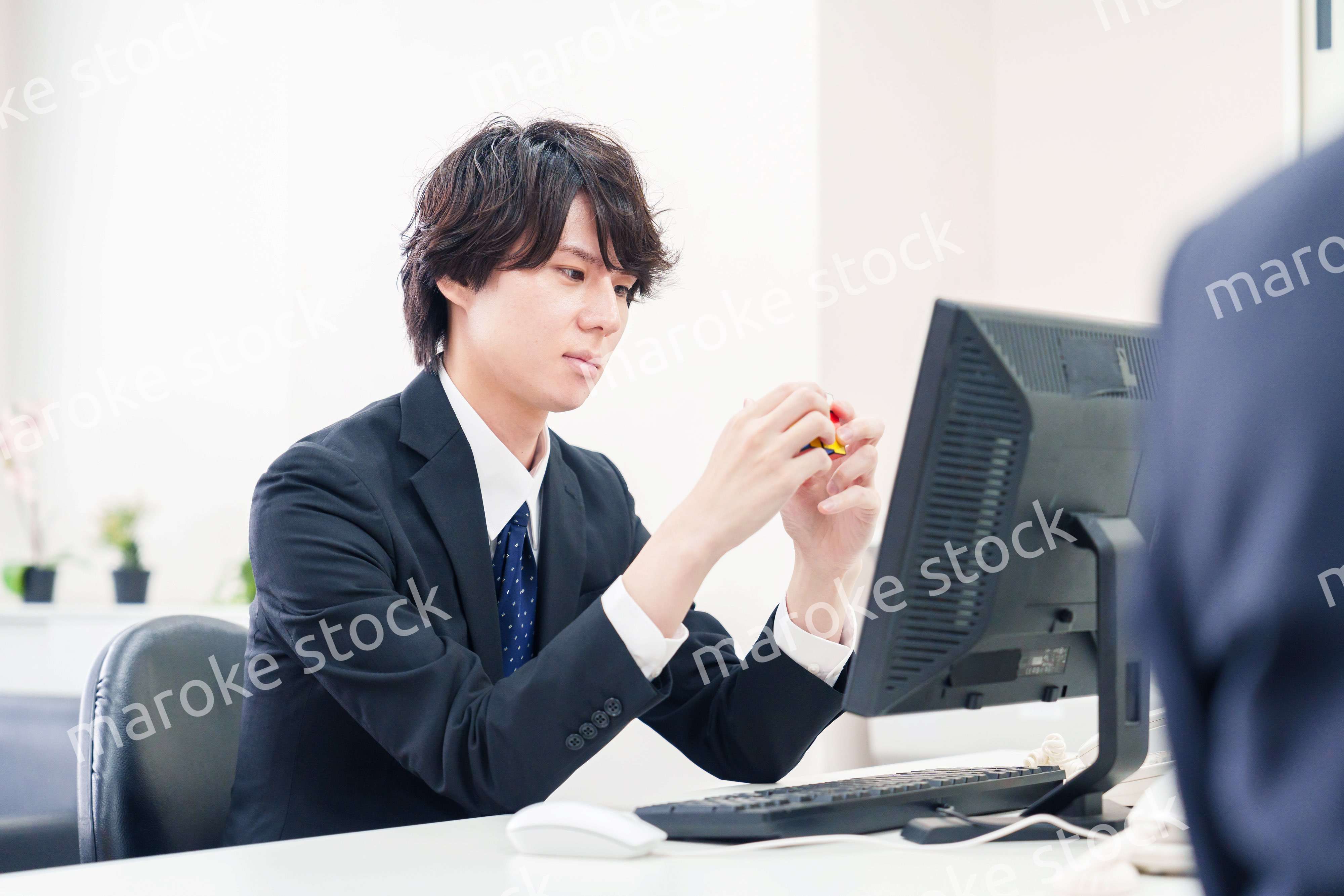 仕事中にルービックキューブをするビジネスマン