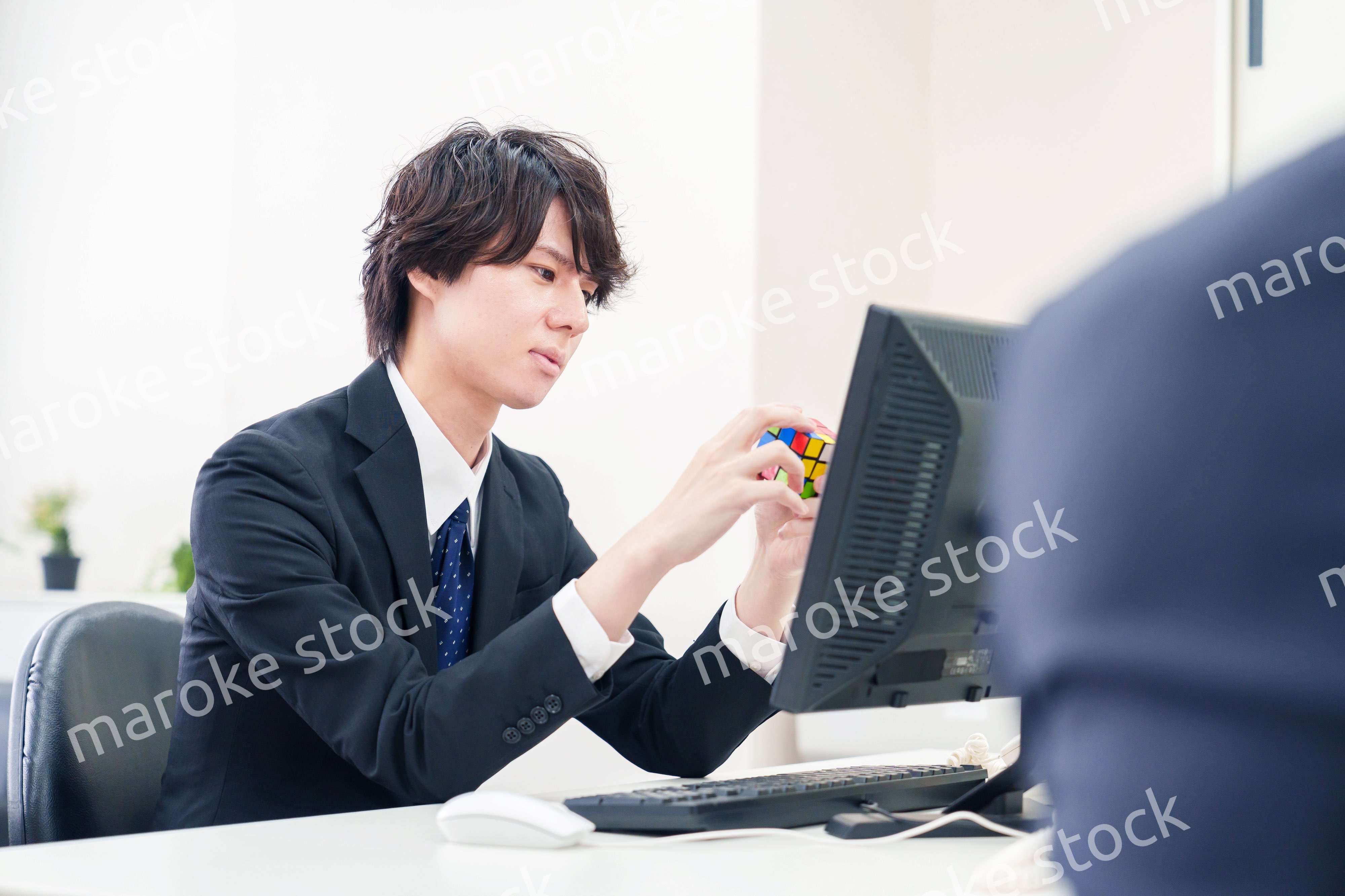 仕事中にルービックキューブをするビジネスマン