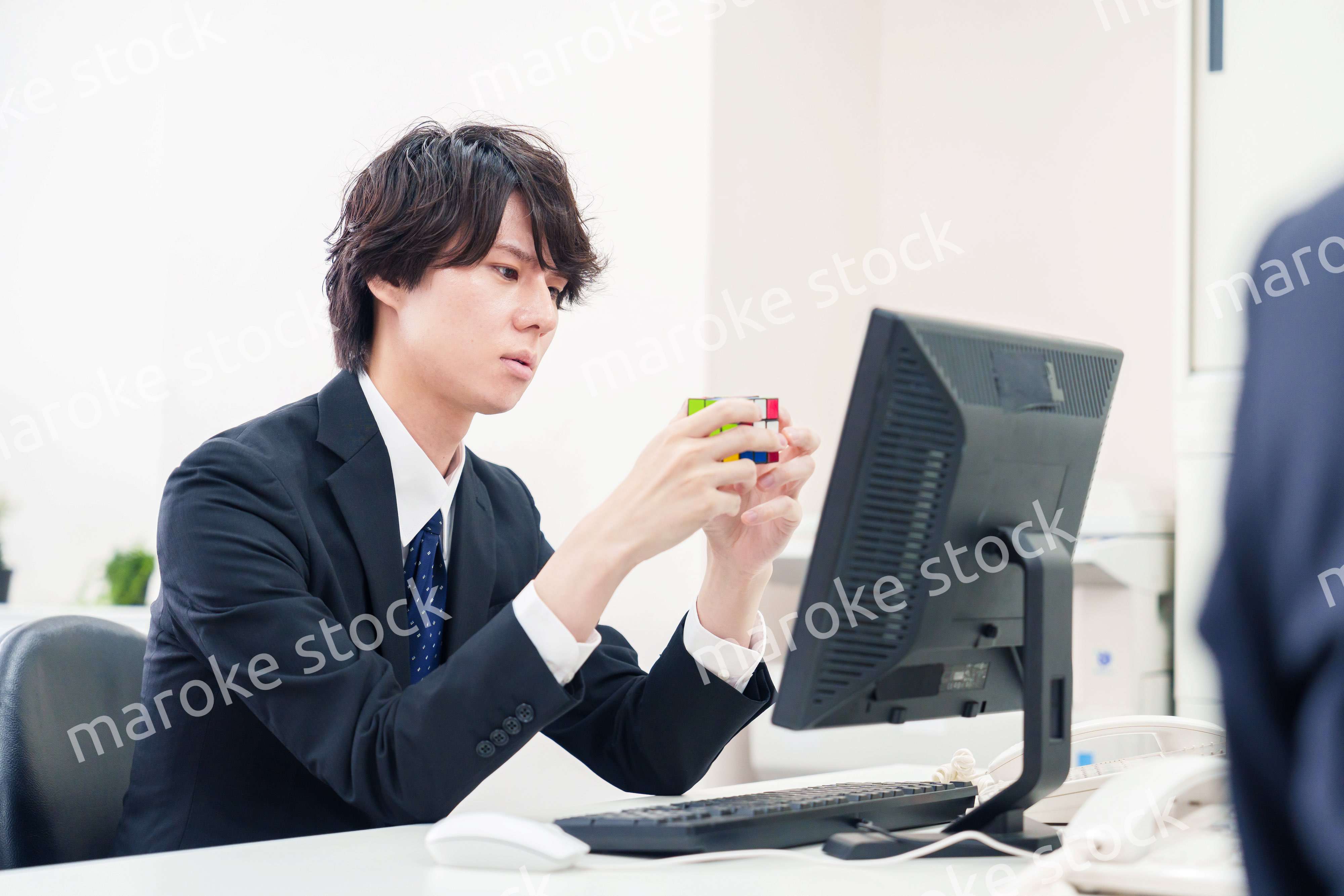 仕事中にルービックキューブをするビジネスマン