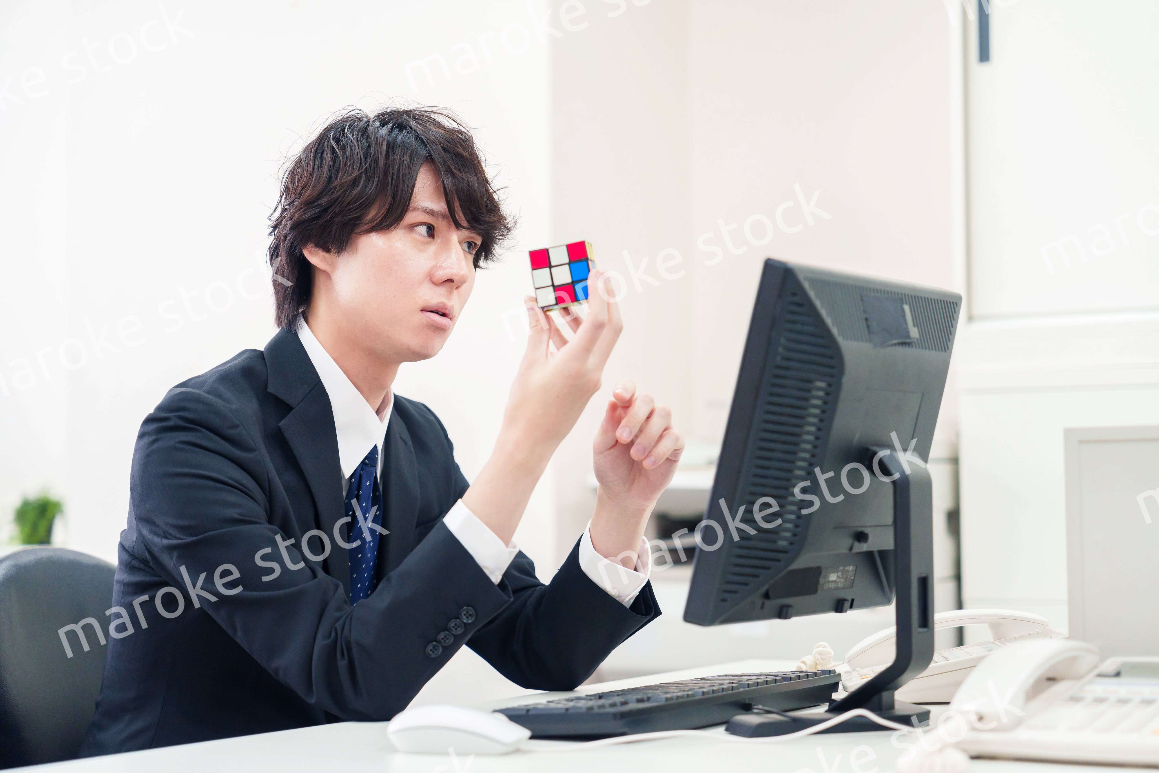 仕事中にルービックキューブをするビジネスマン
